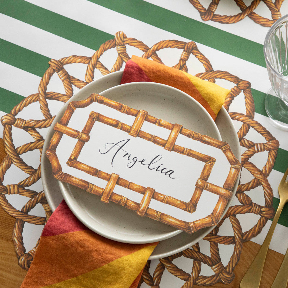Top-down view of an elegant place setting featuring a Bamboo Table Card labeled "Angelica" resting on the plate.