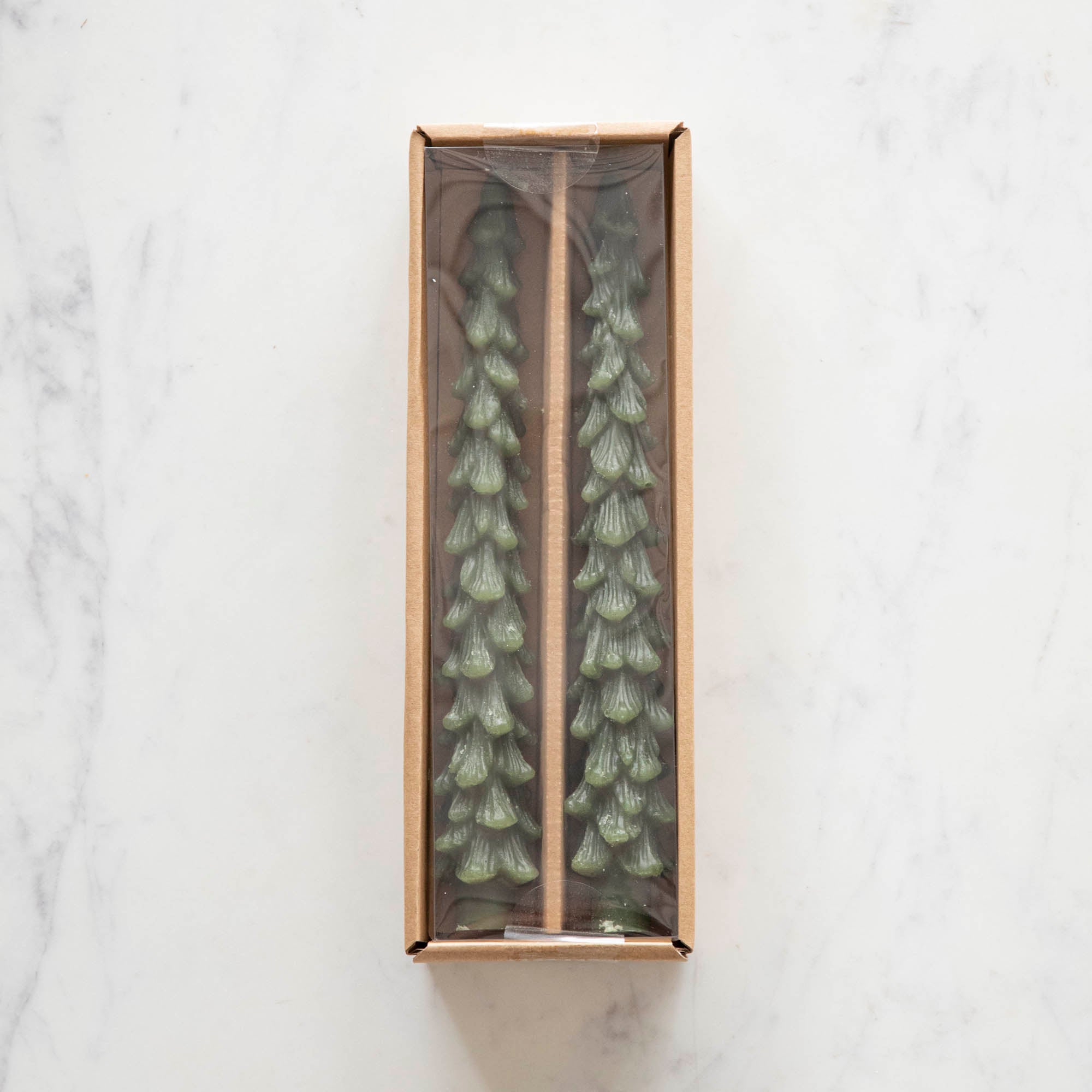 A set of two green tree-shaped taper candles in a box.