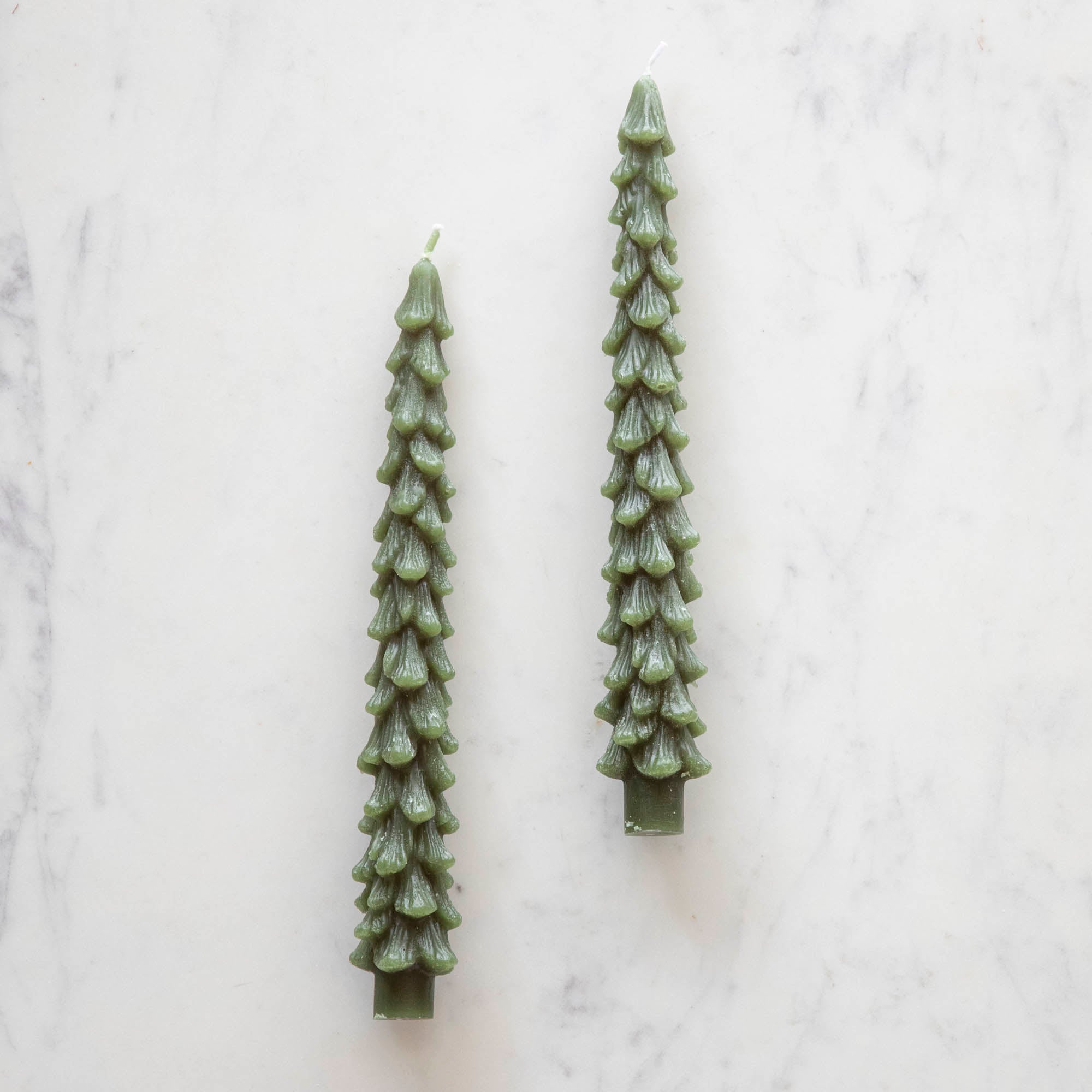 A set of two green tree-shaped taper candles.