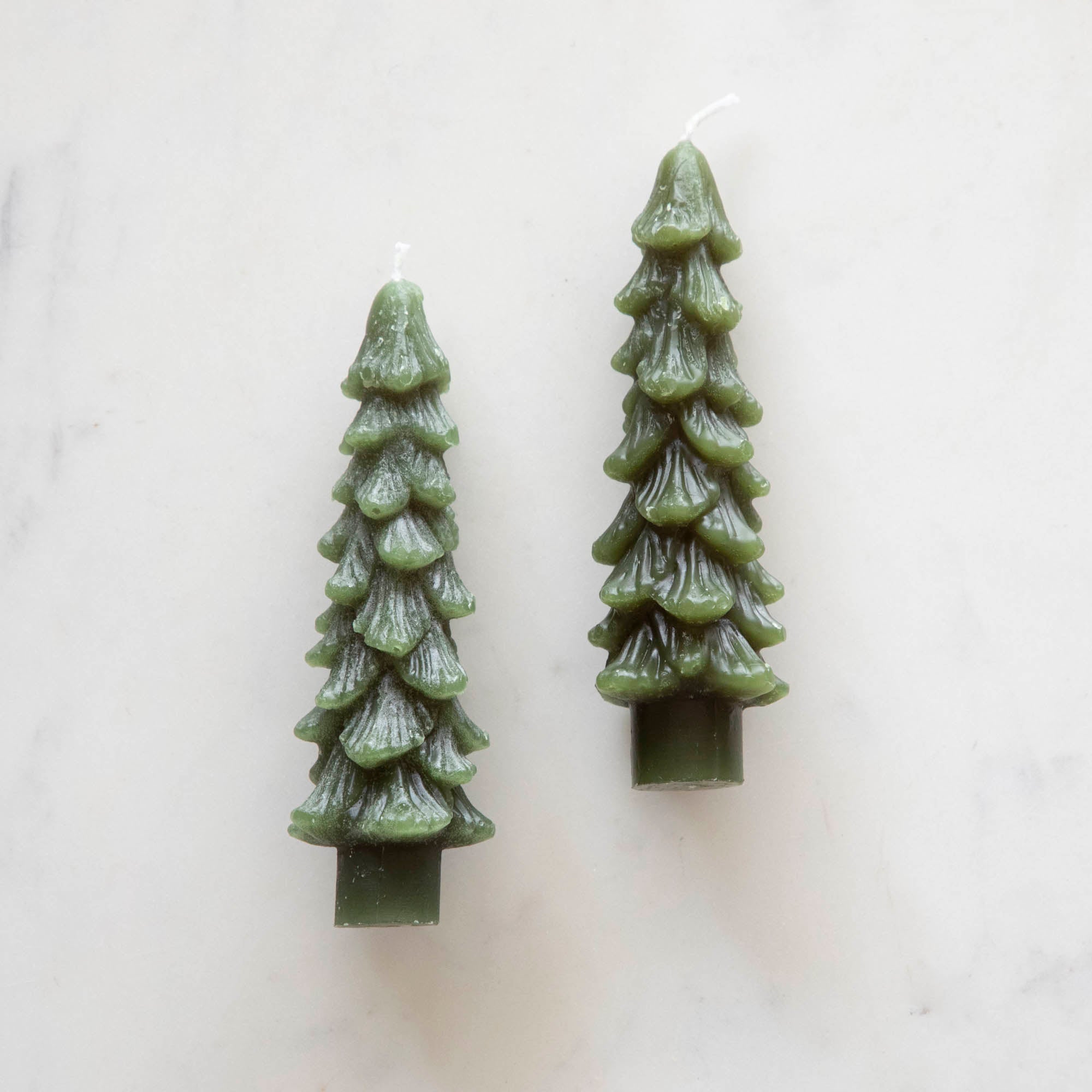 A set of two green tree-shaped taper candles.
