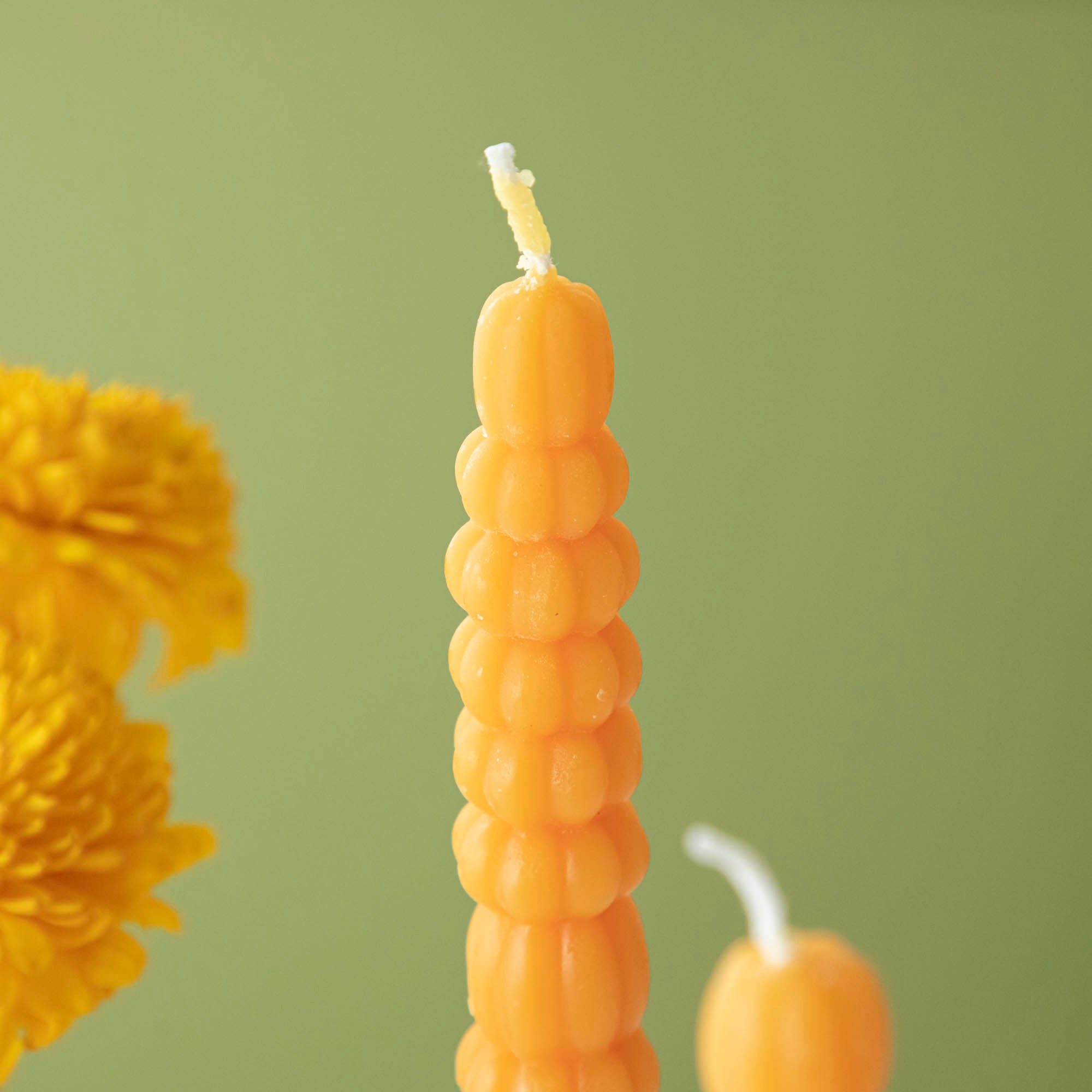 Close-up of the orange pumpkin taper candle.