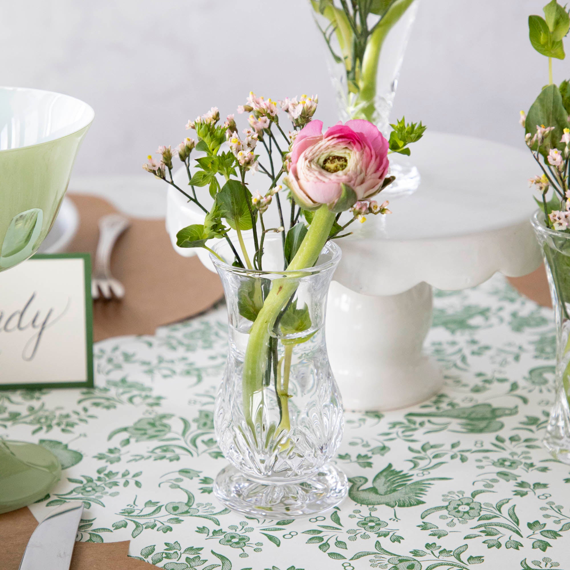 A row of Dublin Crystal 5 Piece Bud Vase Set by Godinger with fresh flowers - perfect for adding a touch of beauty to any space.