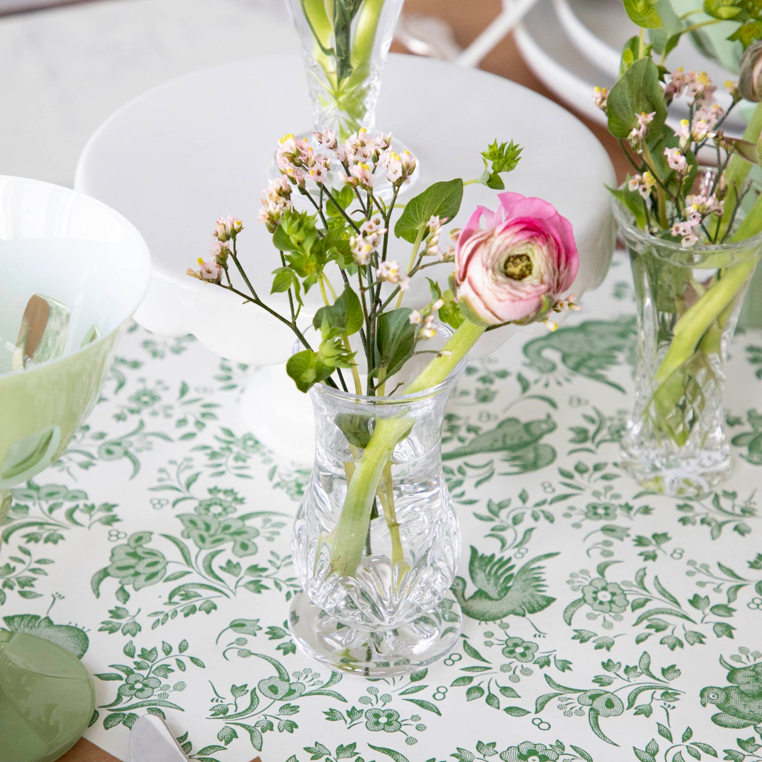 A row of Dublin Crystal 5 Piece Bud Vase Set by Godinger with fresh flowers - perfect for adding a touch of beauty to any space.