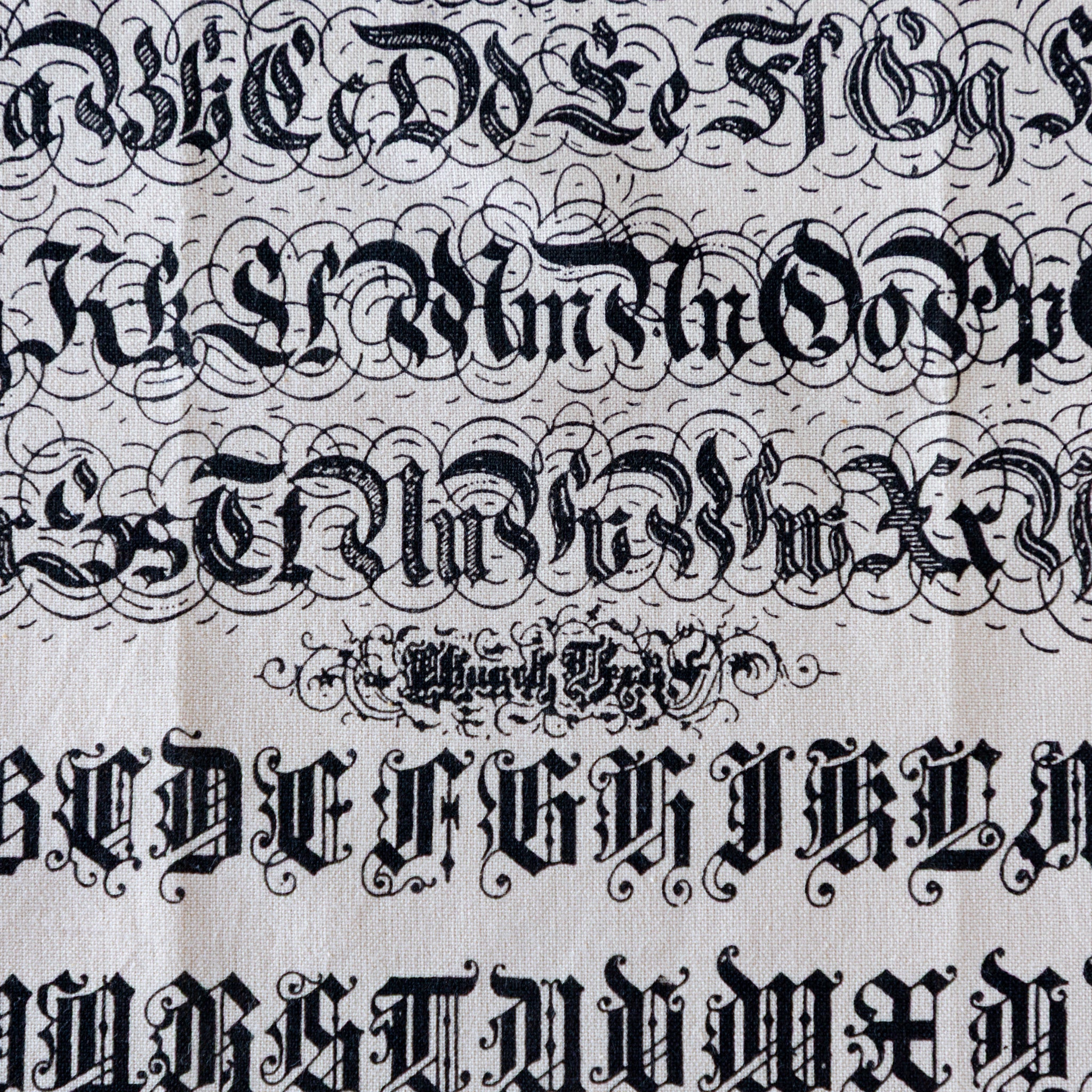A close up of the Old English Tea Towel featuring the alphabet and numbers in old english font.