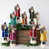 Nine assorted 12" Velvet Belsnickle figurines with a velvet robe adorned with tinsel trimming and glitter, holding a tree.