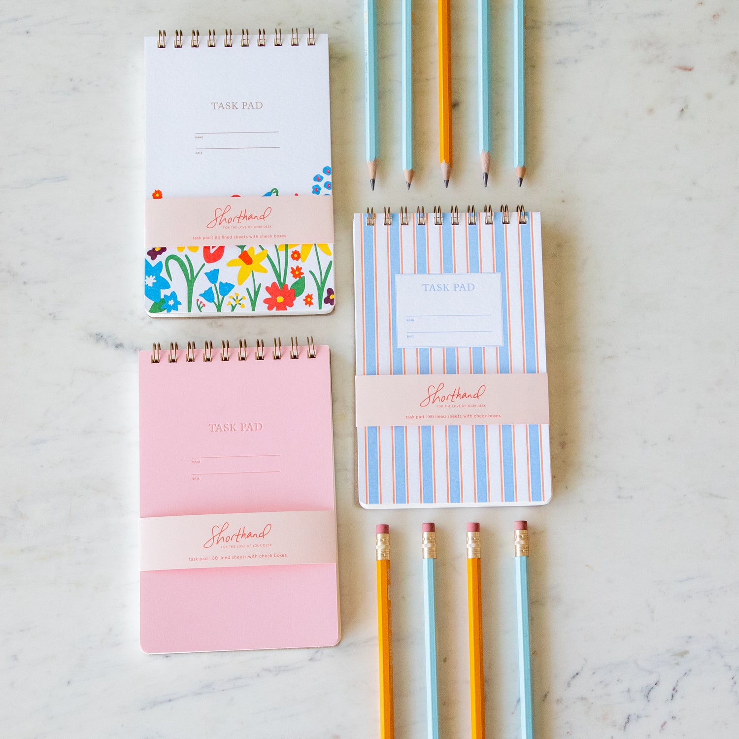 Shorthand Press Task Pads lined up with pencils.