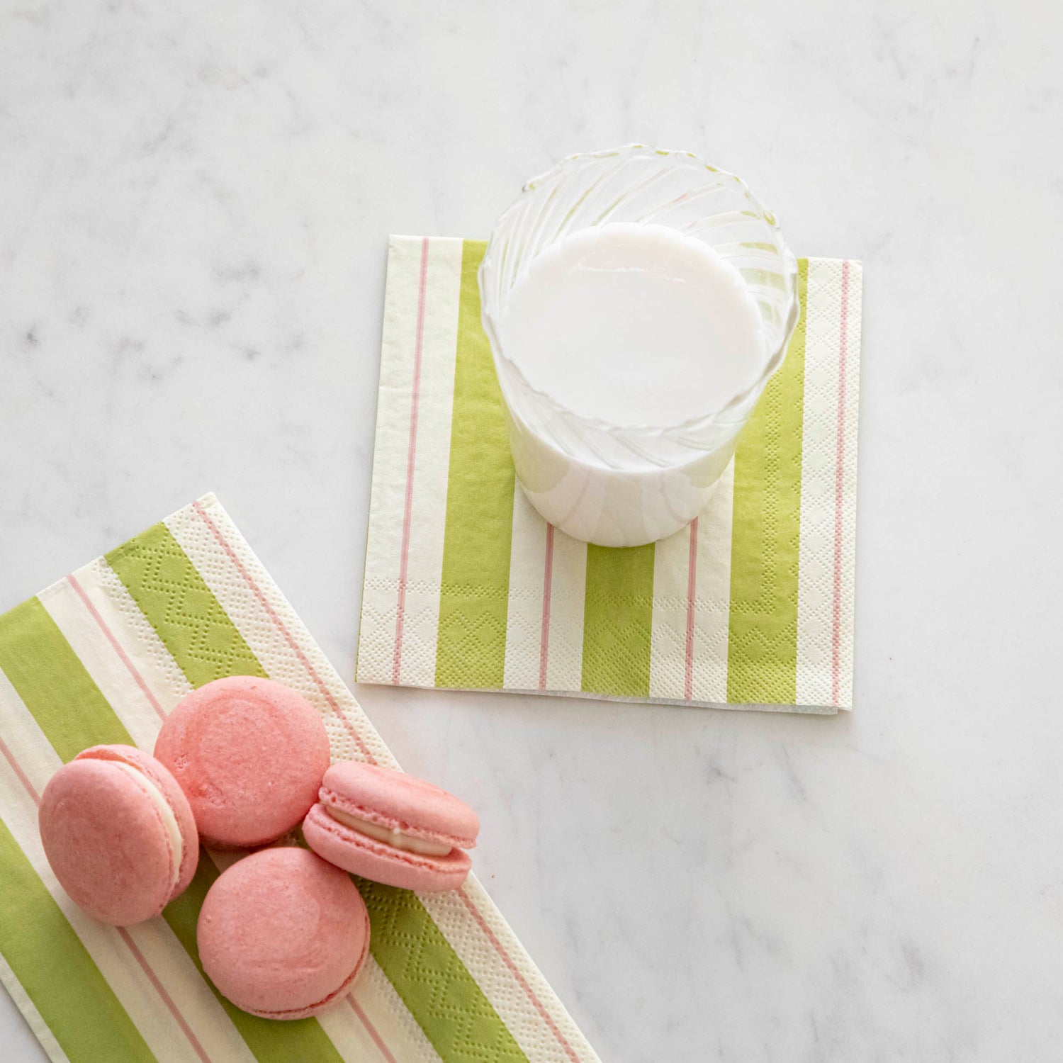 Green & Pink Awning Stripe Cocktail Napkin with a glass of milk on top.