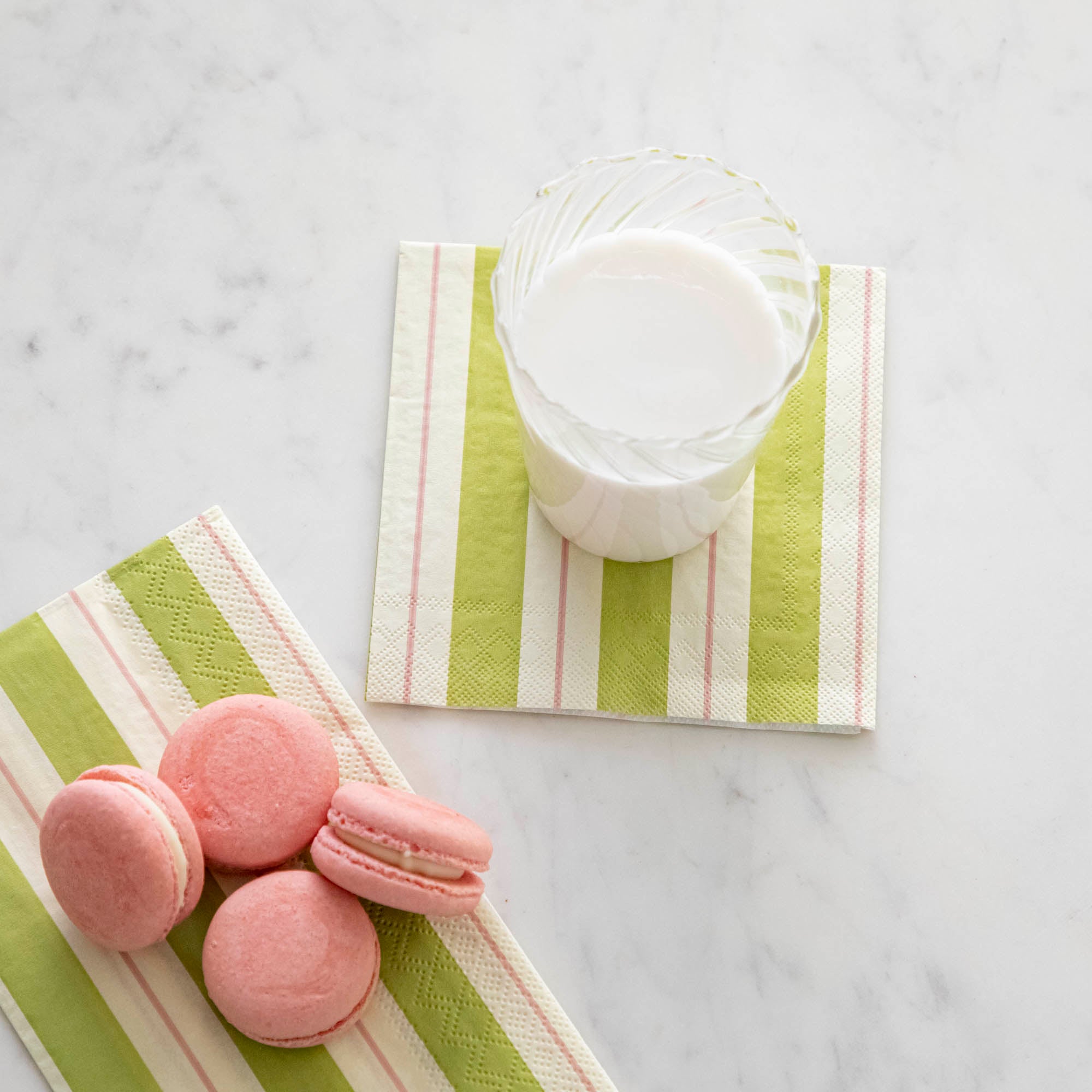 Green & Pink Awning Stripe Cocktail Napkin with a glass of milk on top.