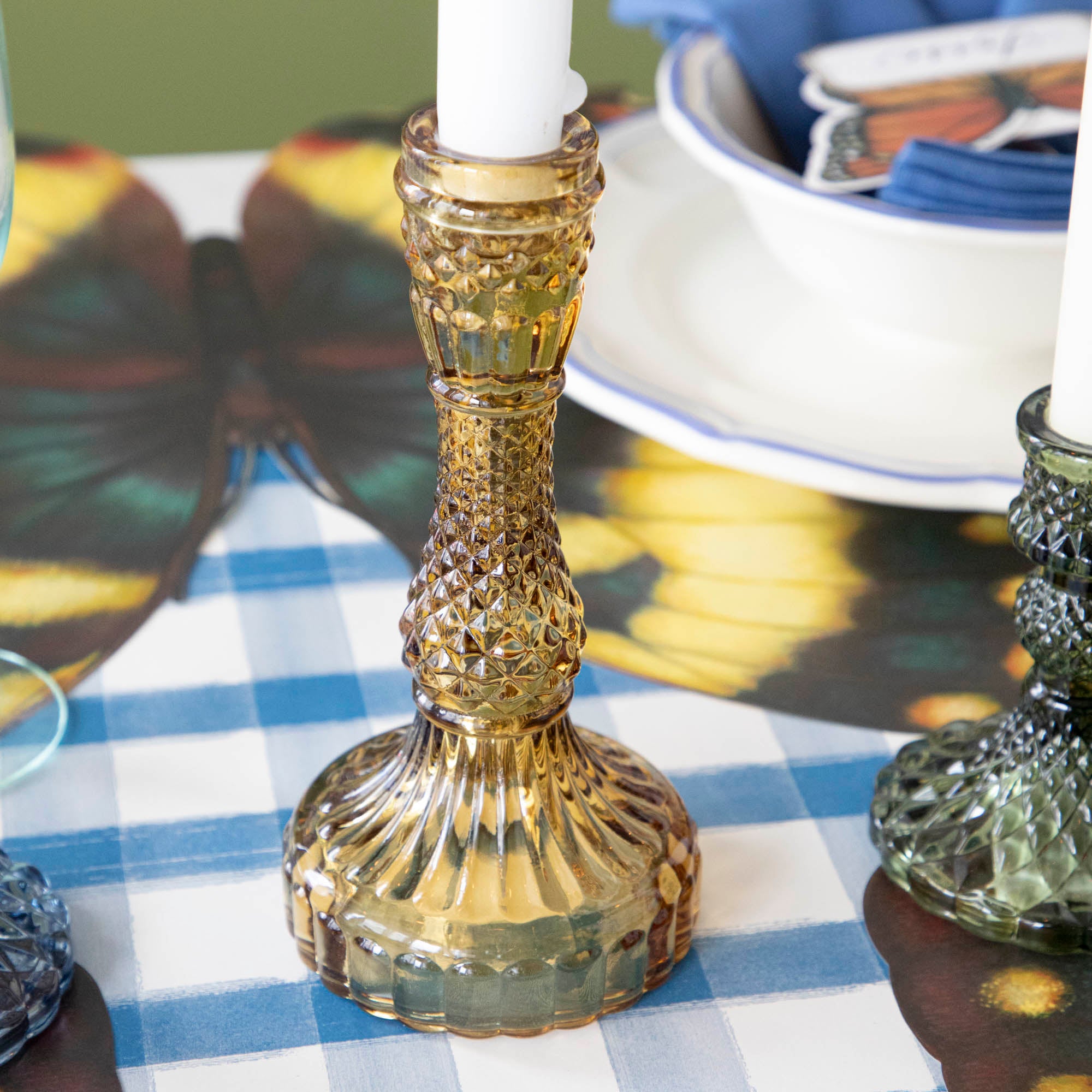 Close-up of an amber candle holder on a set table.
