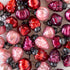 Close-up of red and pink Multi Color Mercury Glass Ornaments on a table.
