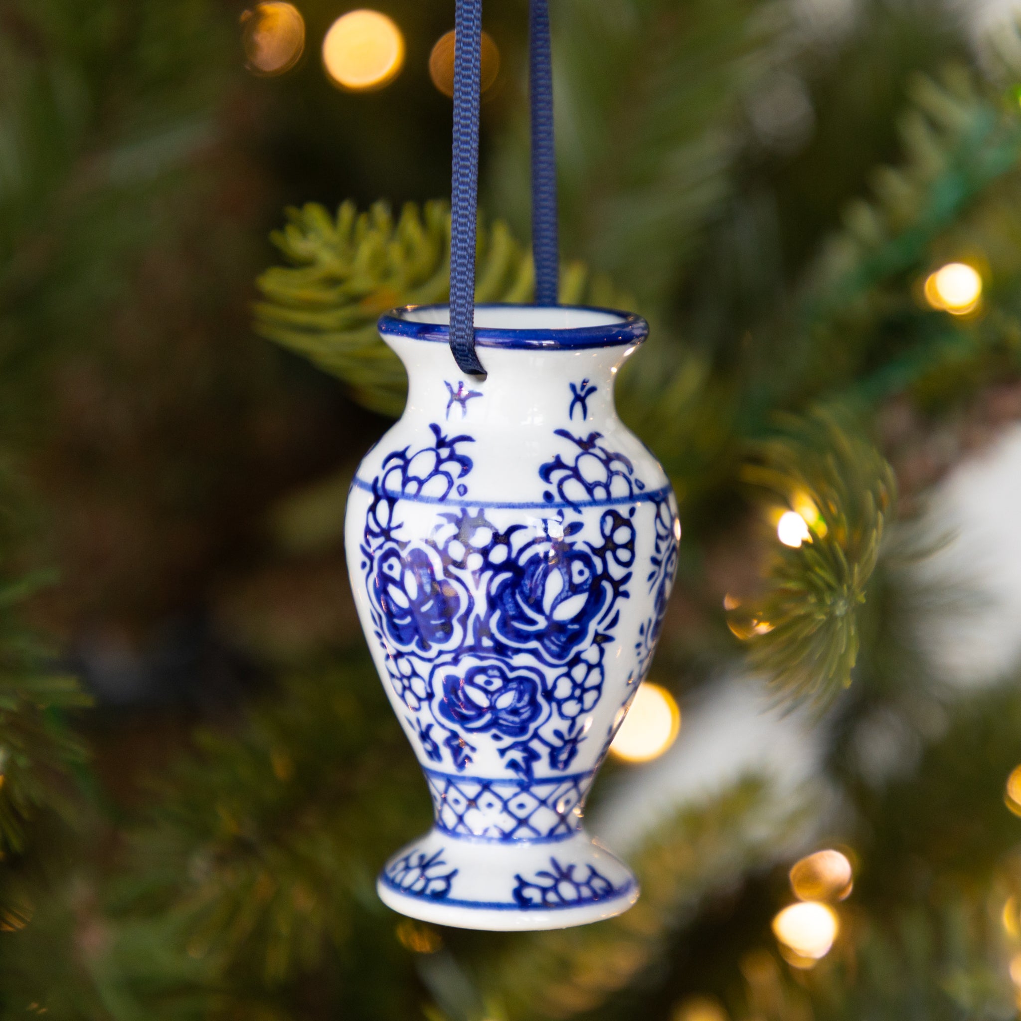 Blue and white decorative vase ornament hanging on a Christmas tree.