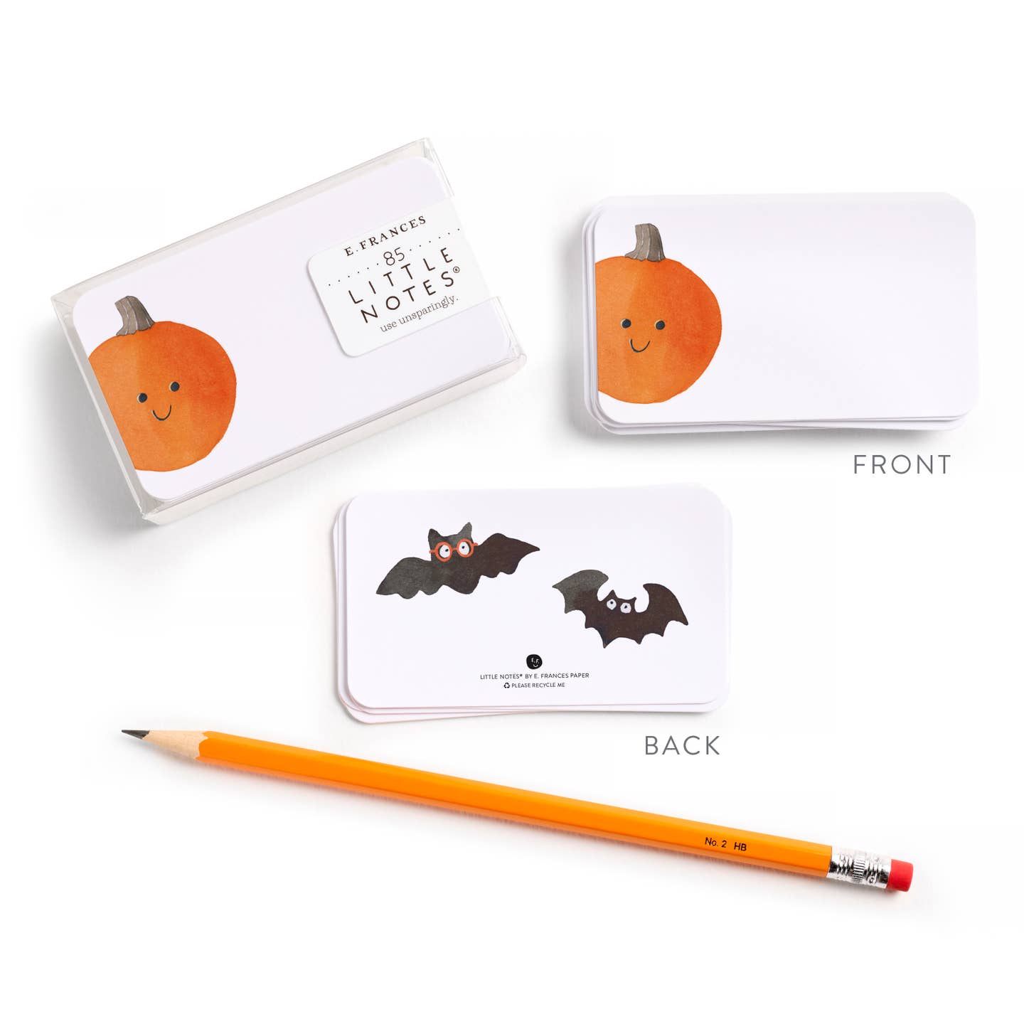 Halloween-themed note card with pumpkins and bats, accompanied by a pencil on a white background.