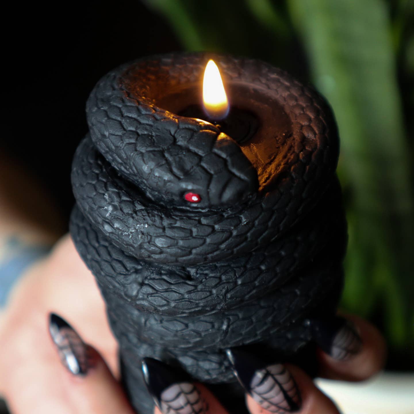 Pillar candle that looks like it has a black snake wrapped around it.