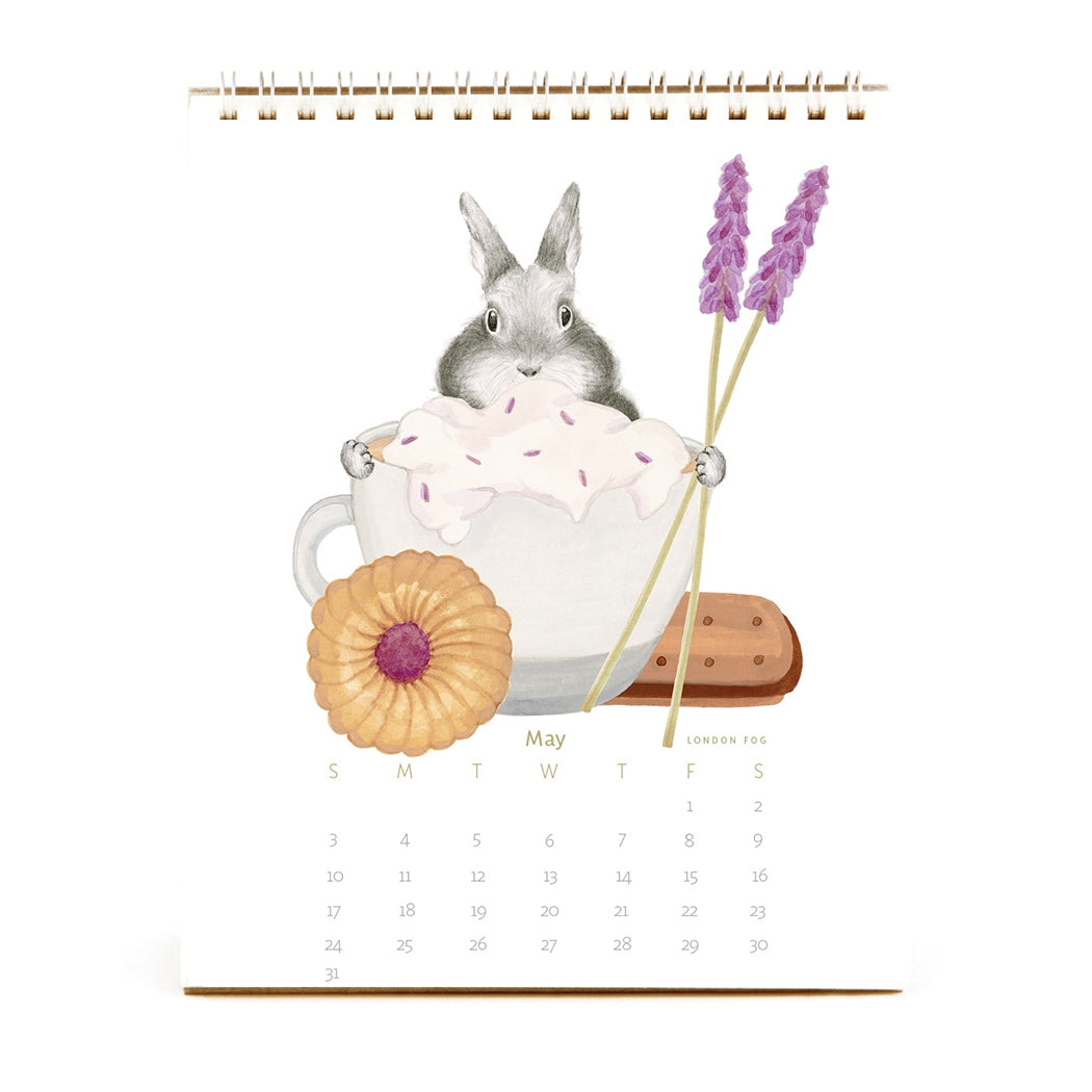 2026 Dear Hancock Bunny Calendar featuring a bunny hiding behind a cup of hot cocoa with whip cream on top and a pastry next to it.