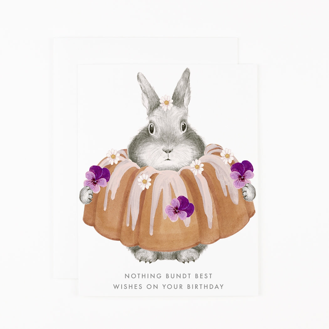 Greeting card by Dear Hancock with an illustration of a bunny in a bundt cake saying &quot;Nothing bundt best wishes on your Birthday&quot;. 