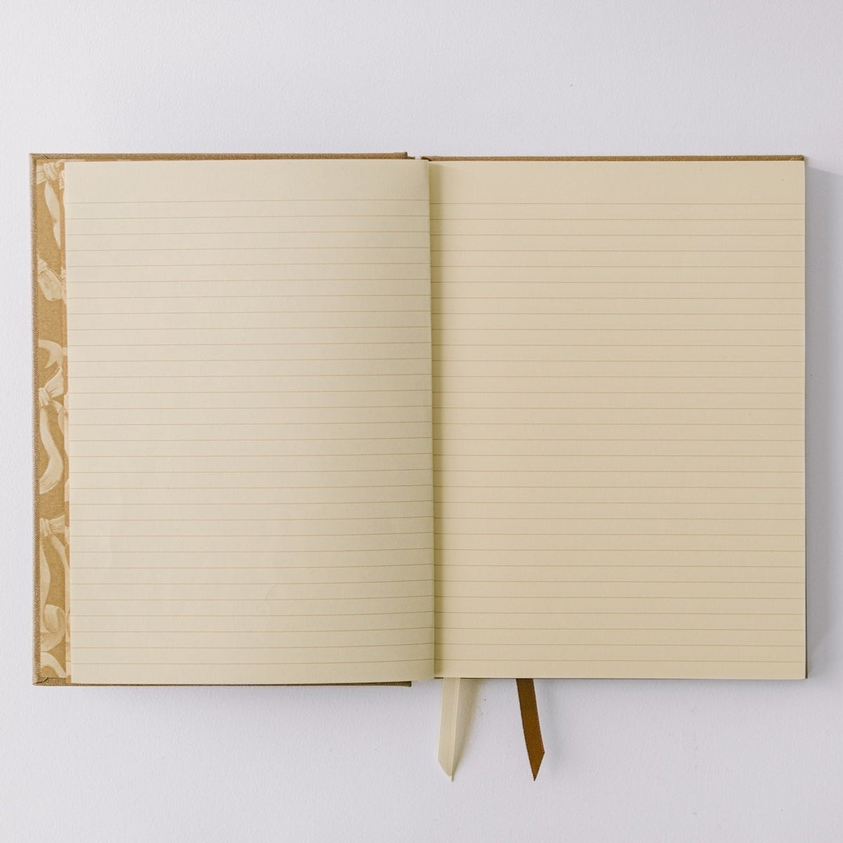 Notebook by Good Juju with gold detailing depicting a bow. 