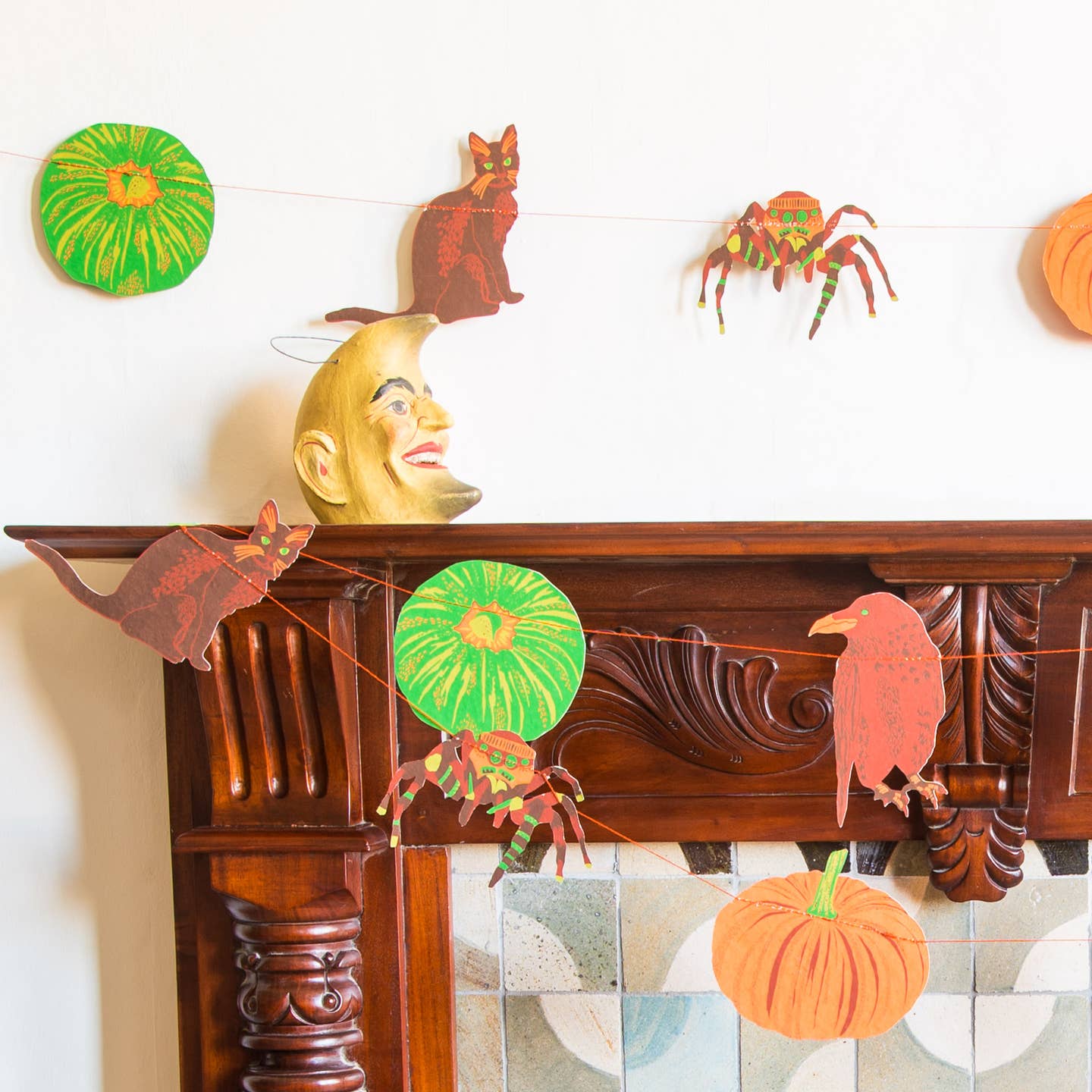 Pumpkin garland hanging on a mantle.