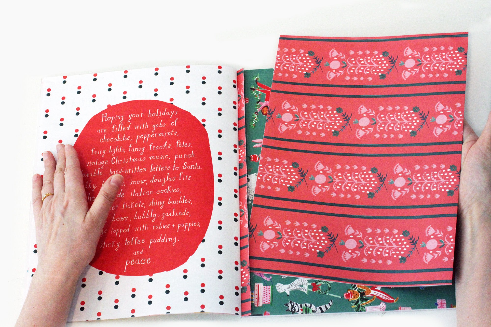 Hands taking out a sheet of wrapping paper from the wrapping paper book.