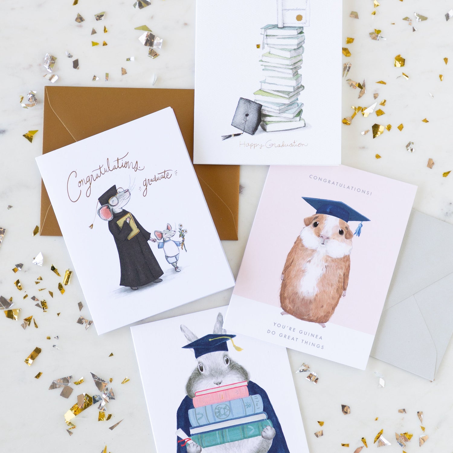 Graduation cards arranged on a table surrounded by gold and silver confetti pieces.