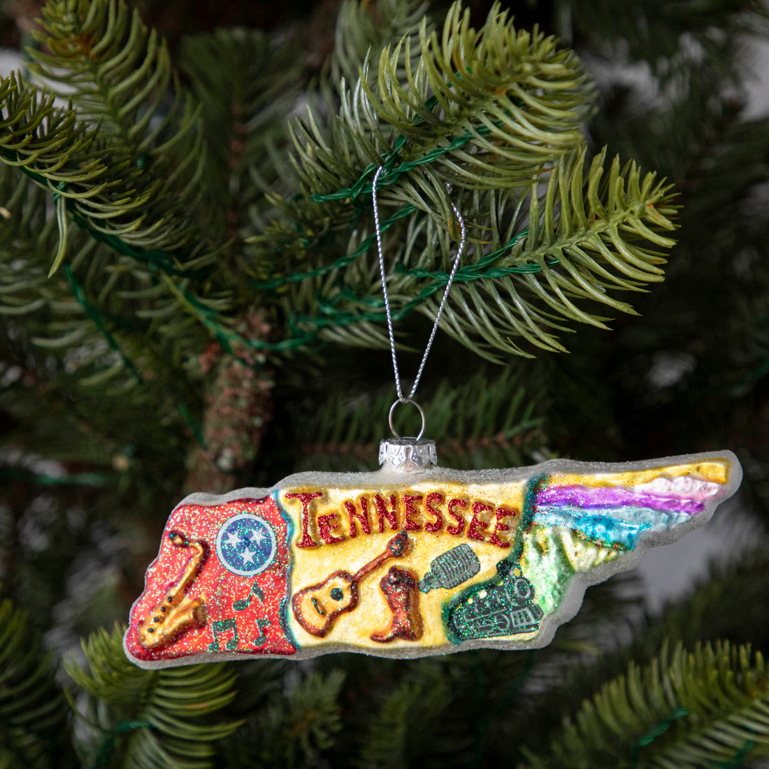 The Tennessee Ornament displaying a classic representation of the state of Tennessee, hanging on a tree.