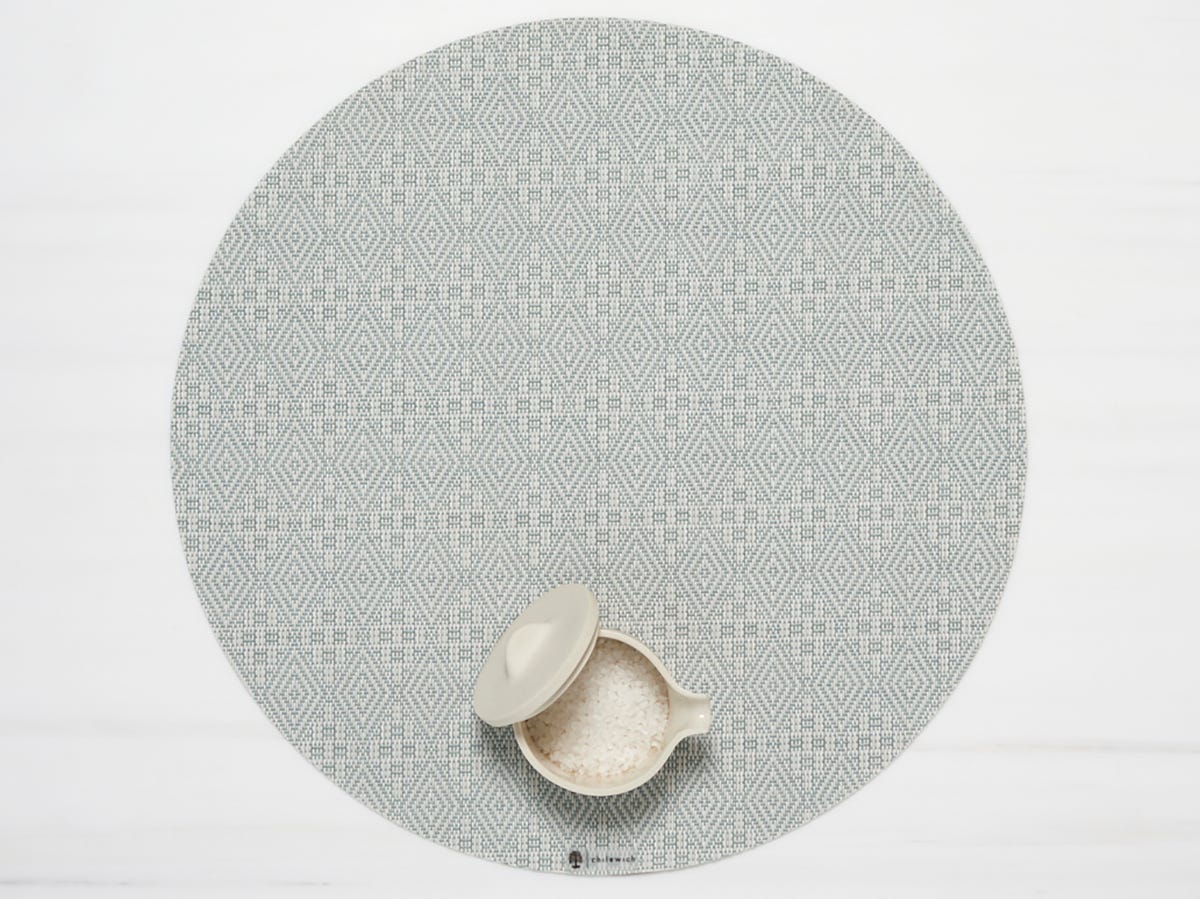 Boxwood Round Placemat with small container of grains on it in the Abolene color