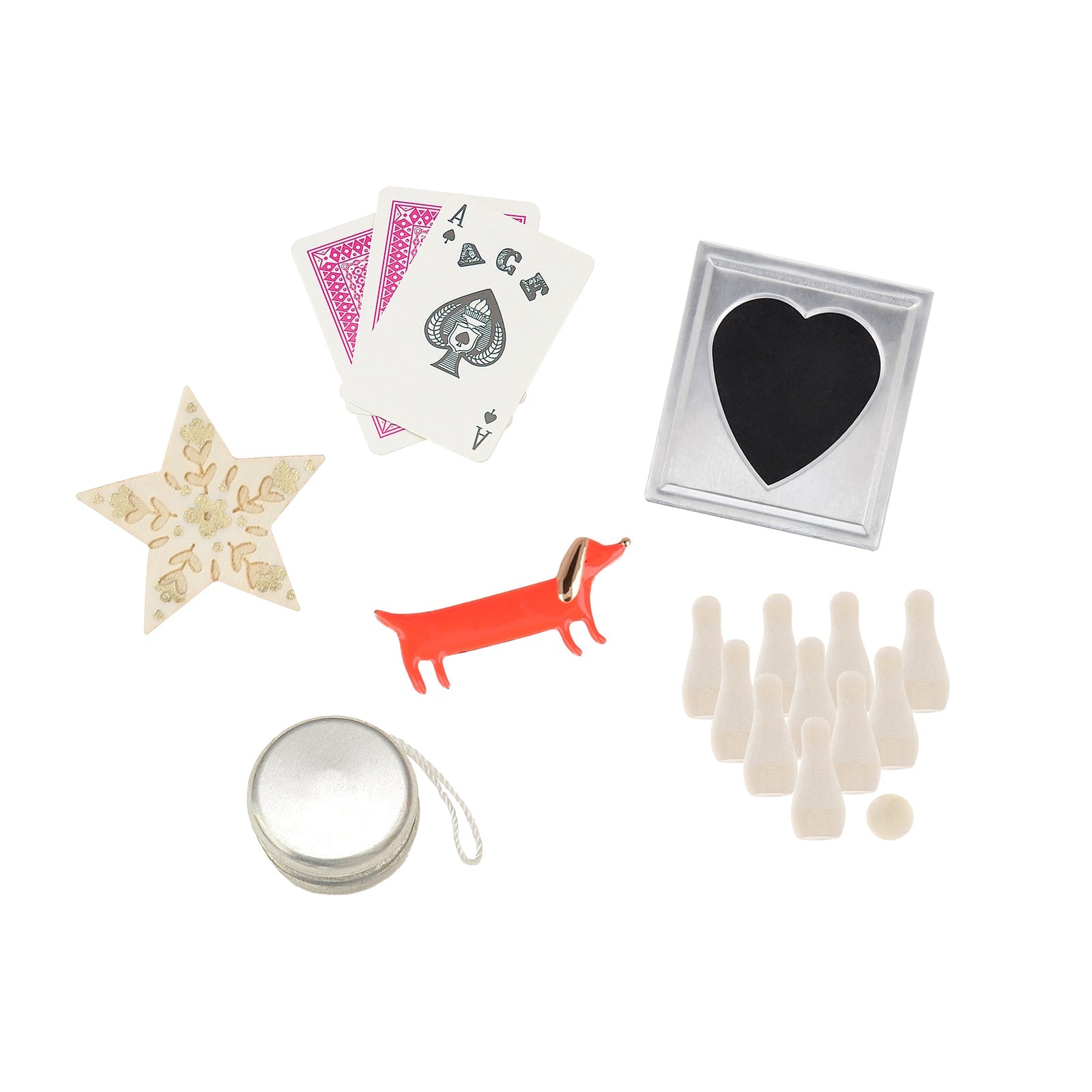 Collection of small items including playing cards, a star-shaped object, a dog figurine, a heart-shaped item, a silver container, and bowling pins on a white background.
