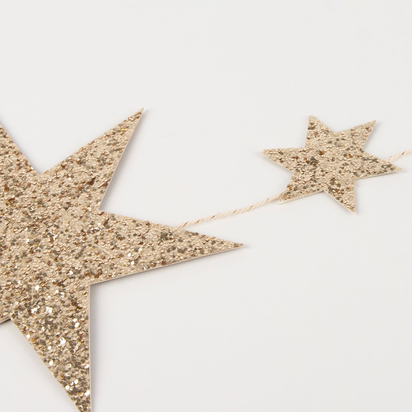 Gold glitter star-shaped decorations on a white background.