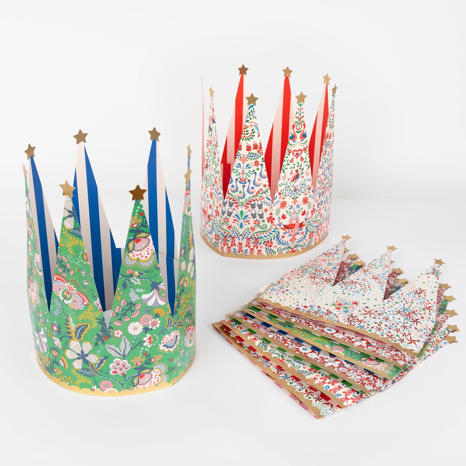 Colorful paper crowns with floral and nature-themed designs on a white background