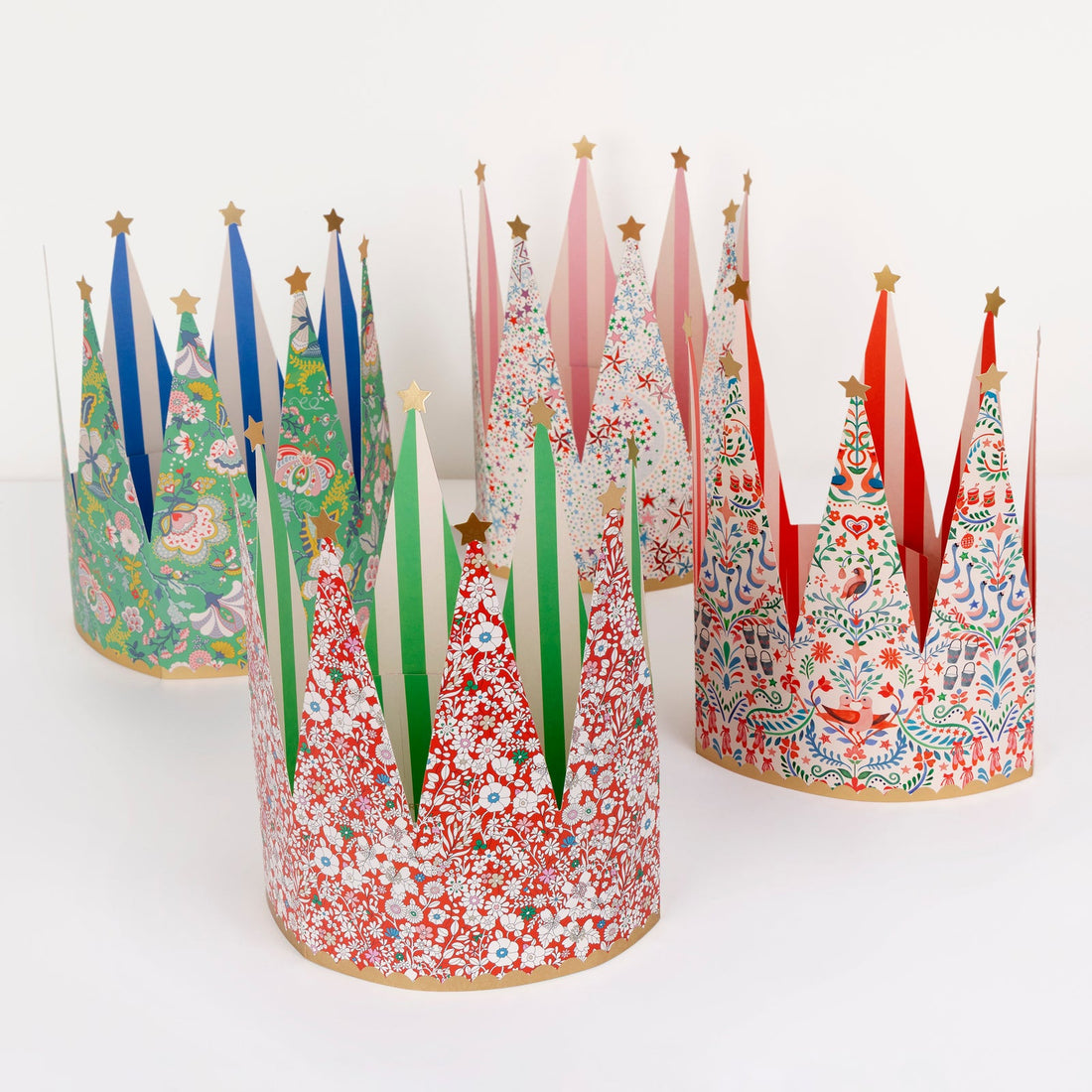 Colorful paper crowns with festive designs on a white background.