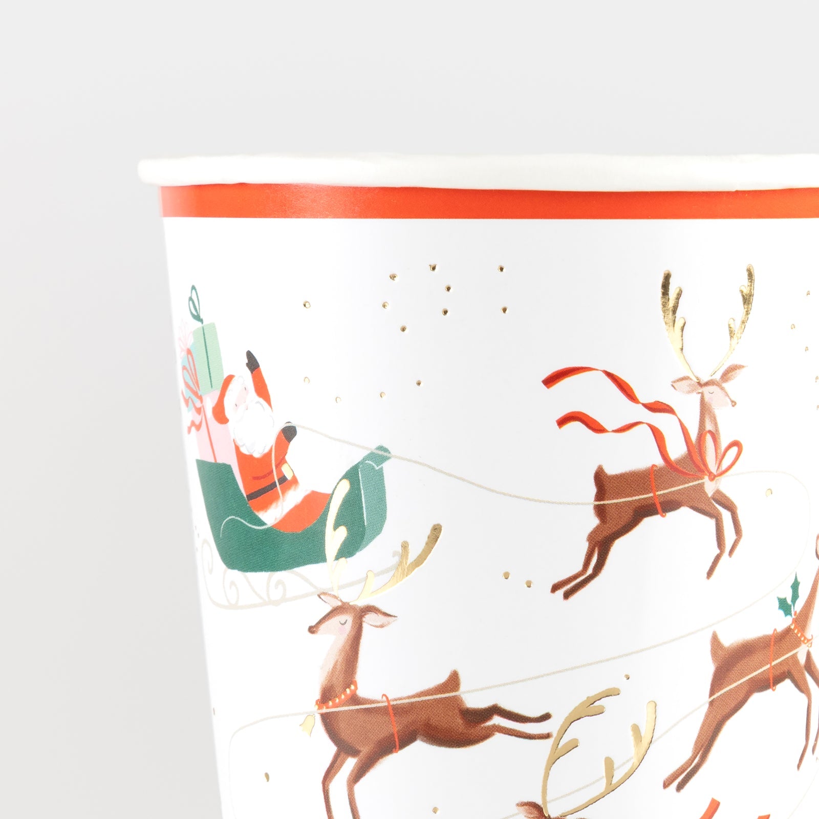 Paper cup by Meri Meri with an illustration of Santa and his reindeer on it.