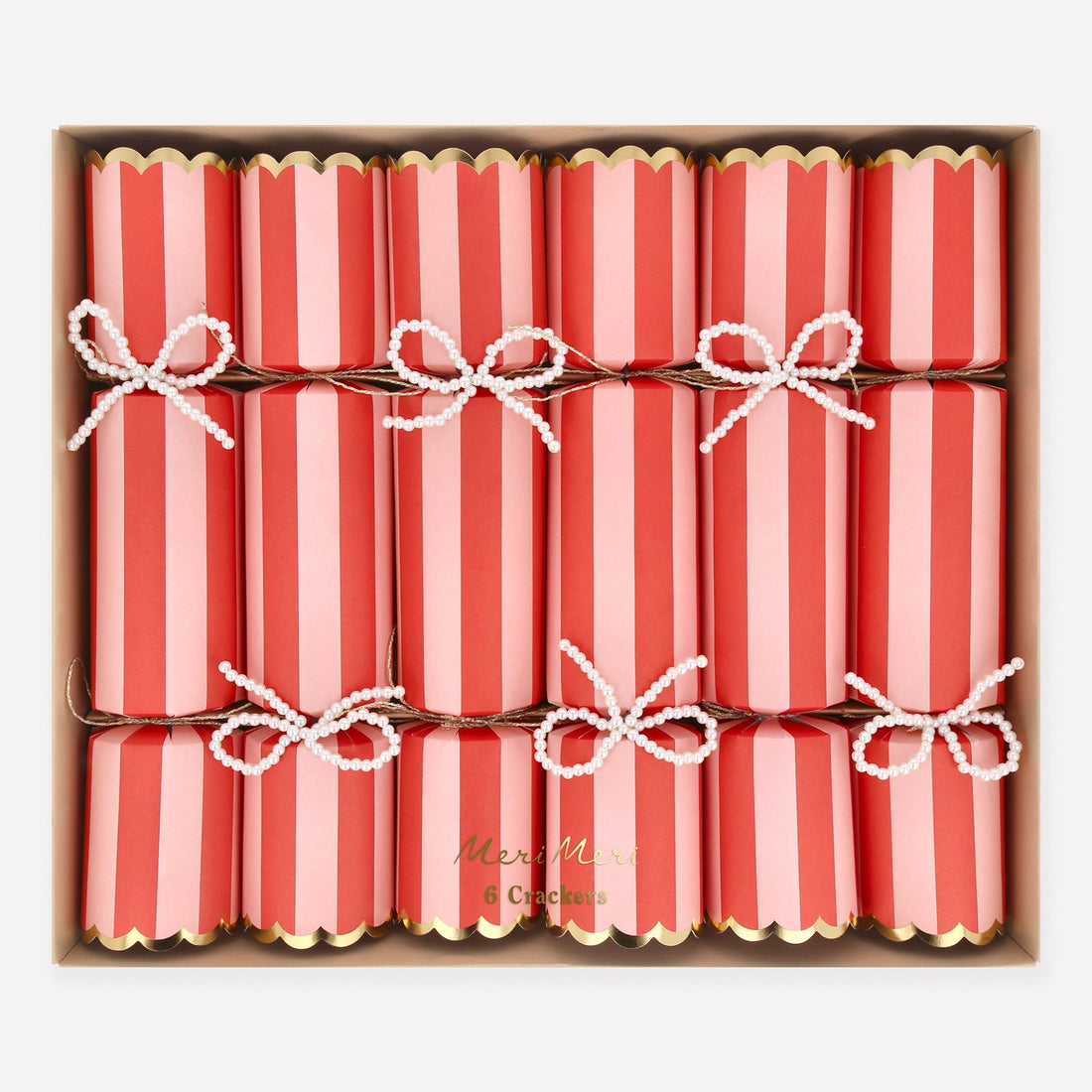 Box of red and pink striped crackers with white bows in a decorative box.