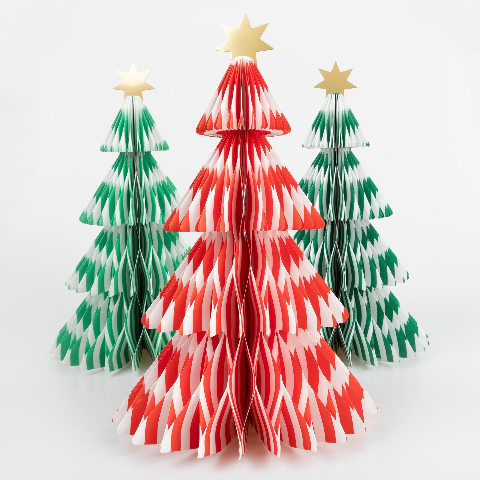 Three paper Christmas trees in red, green, and white on a white background.