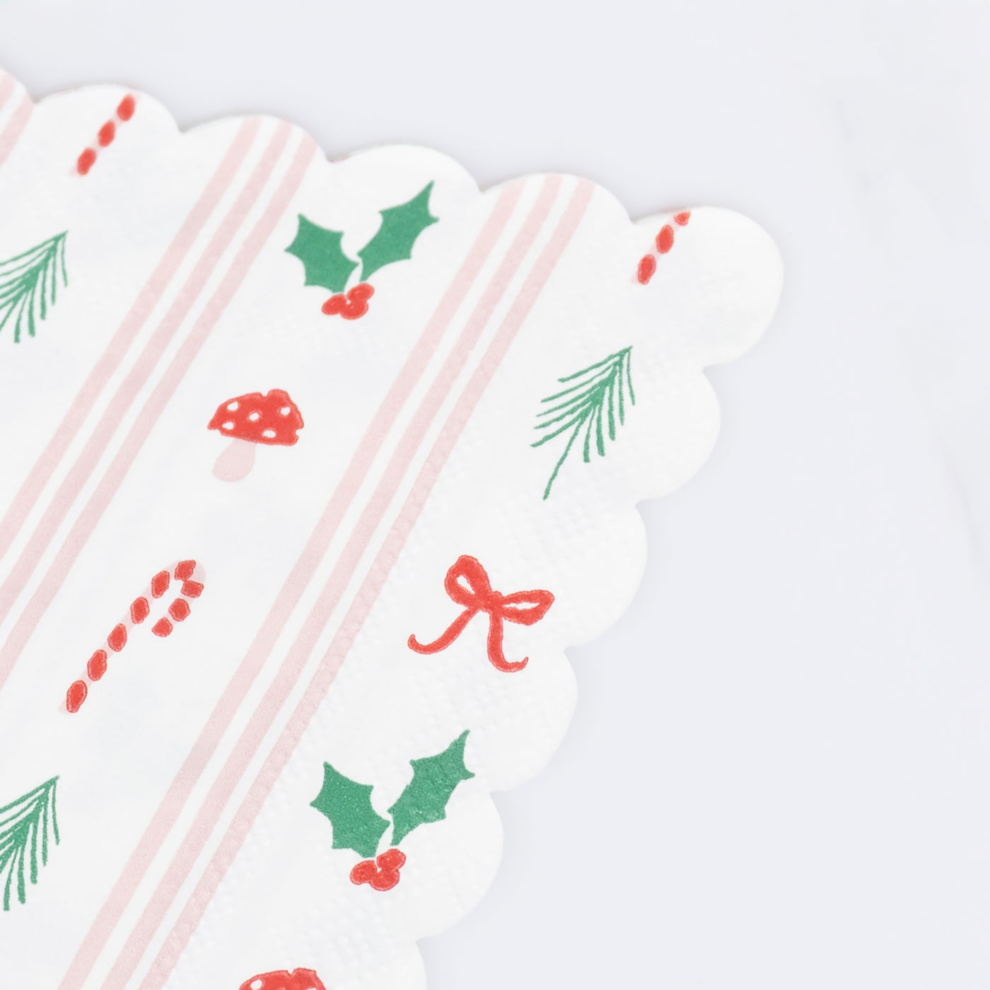 Patterned paper napkin by Meri Meri with small Holiday themed images.