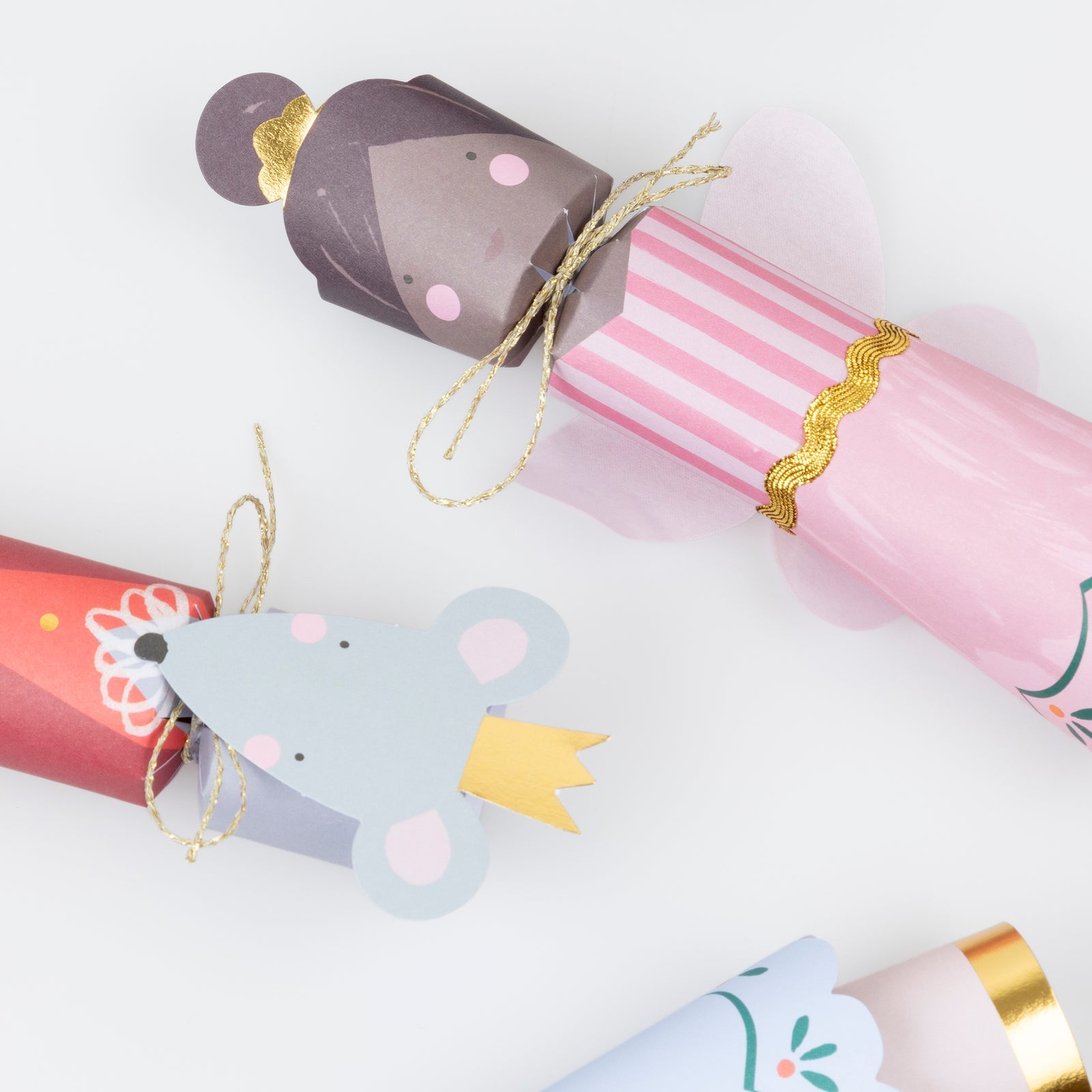 Decorative paper cracker shaped like a mouse with a pink bow on a white background.