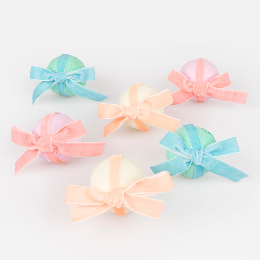 6 Surprise balls with big velvet ribbon bows in pink, peach and blue and wrapped in crepe paper layers of pale yellow, light pink and mint.