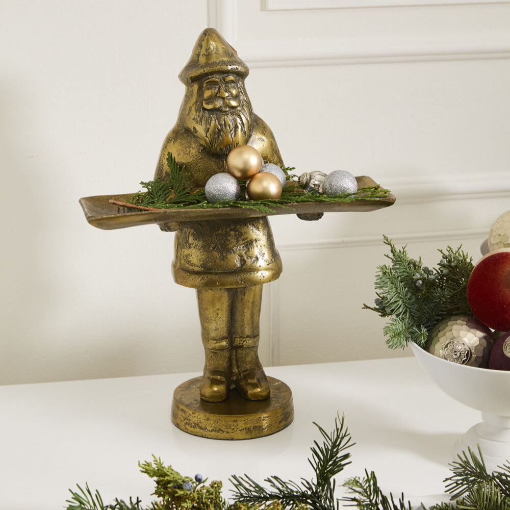 Saint Nick Dish Stand on a Christmas decorated mantle with ornaments and greenery on its tray.