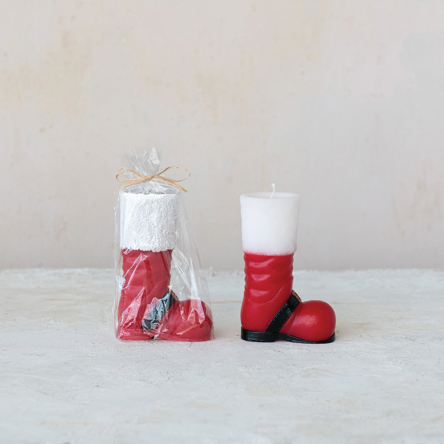 Red boot-shaped candles with a white top on a light background