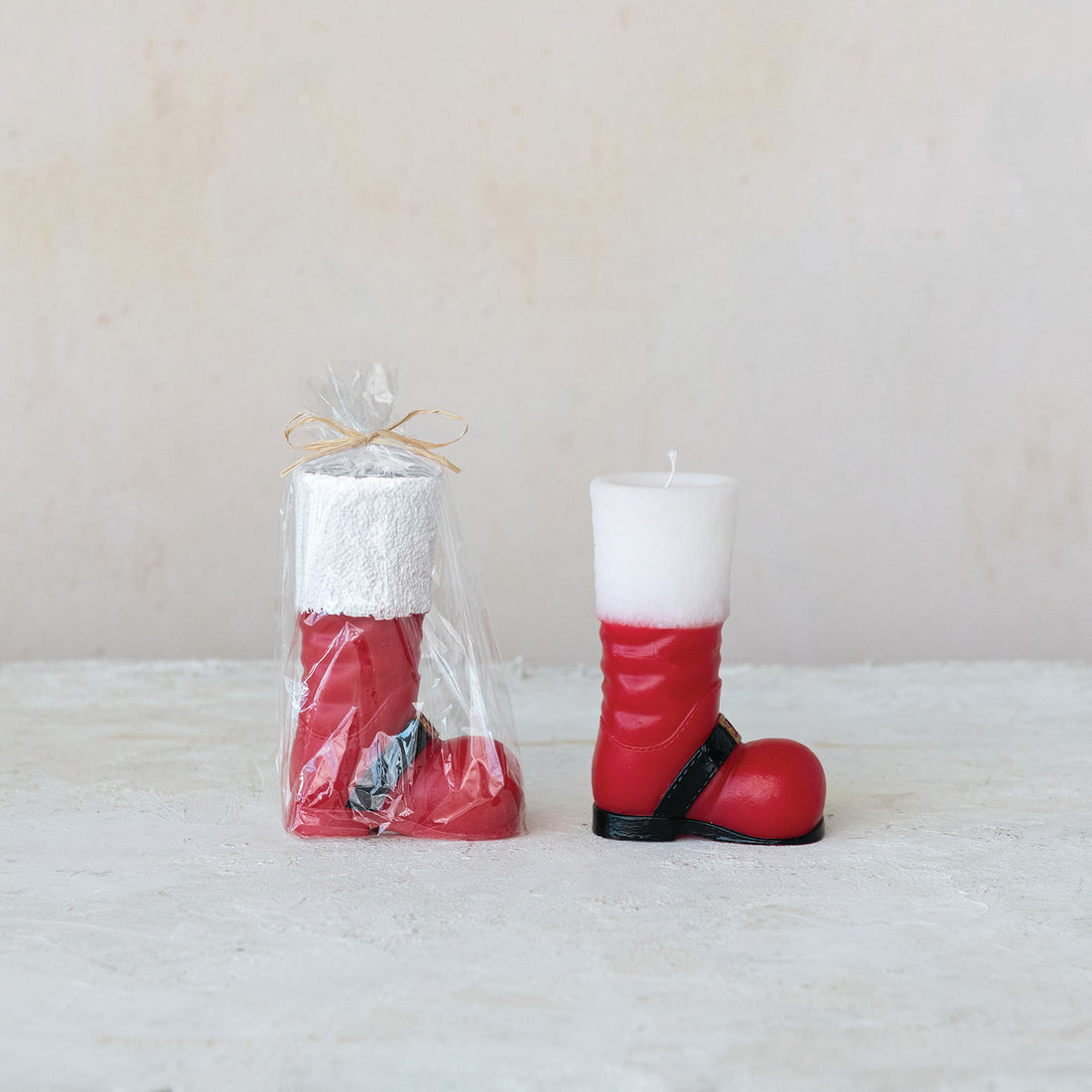 Red boot-shaped candles with a white top on a light background