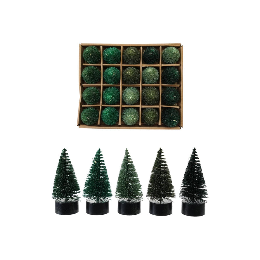 Set of small green Christmas trees in front of a box of green baubles.