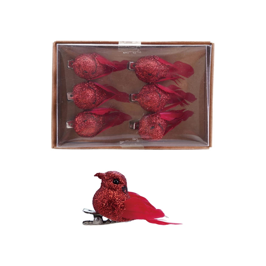 Red glittery bird clips with a clear box on a white background