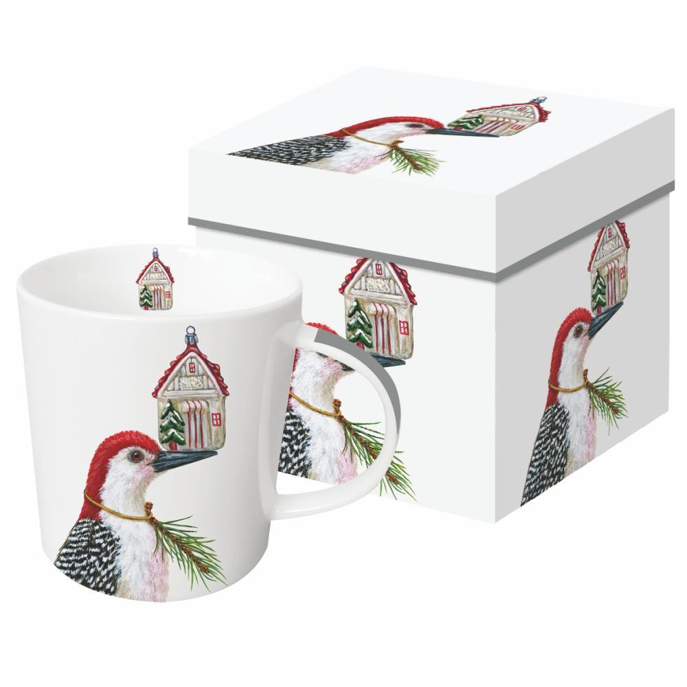 Ceramic mug featuring artwork by Vicki Sawyer showing a bird holding an ornament on its beak.  
