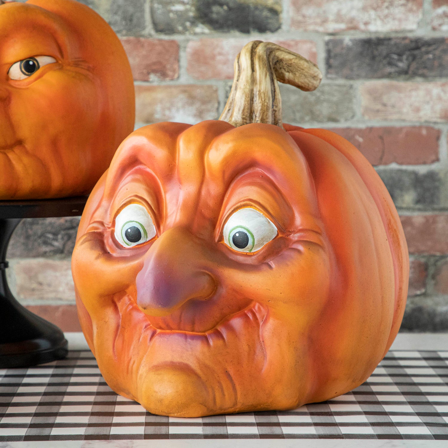 A resin pumpkin with a surprised looking face on it. 