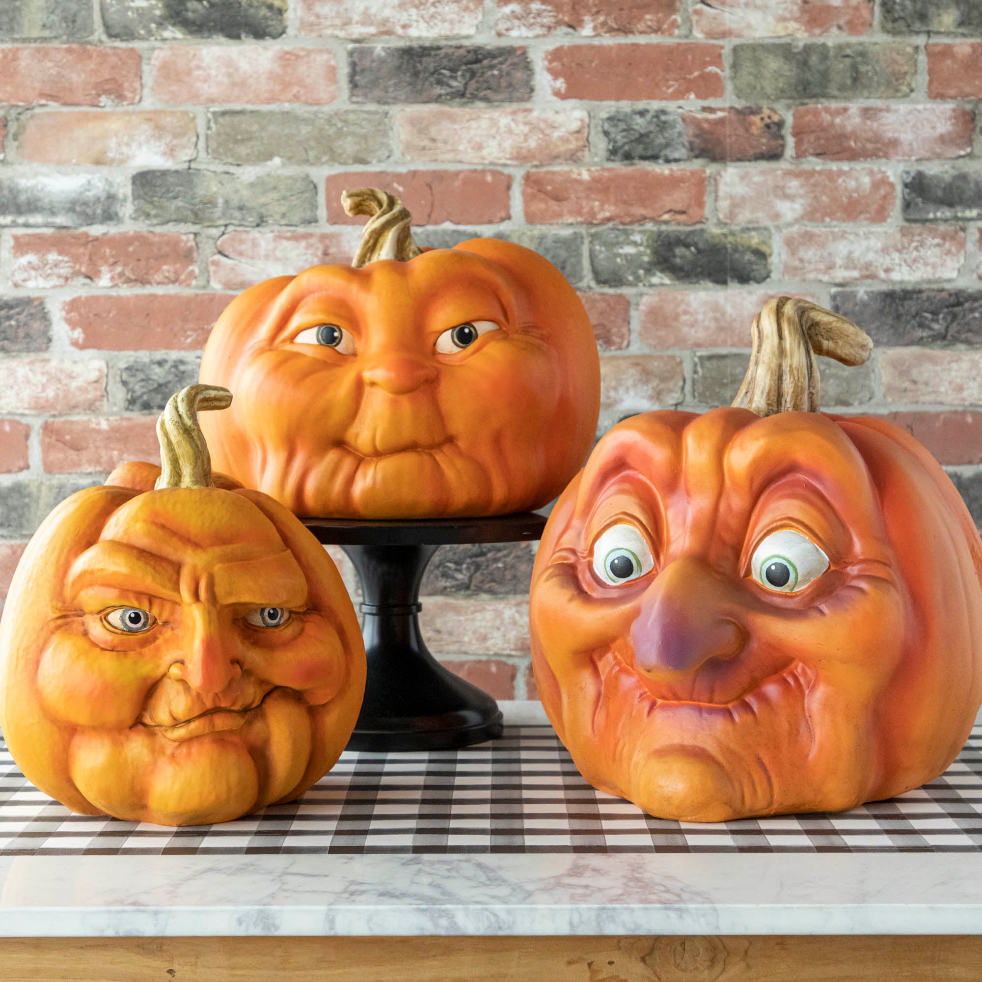 Three resin pumpkins with  assorted faces on them. 