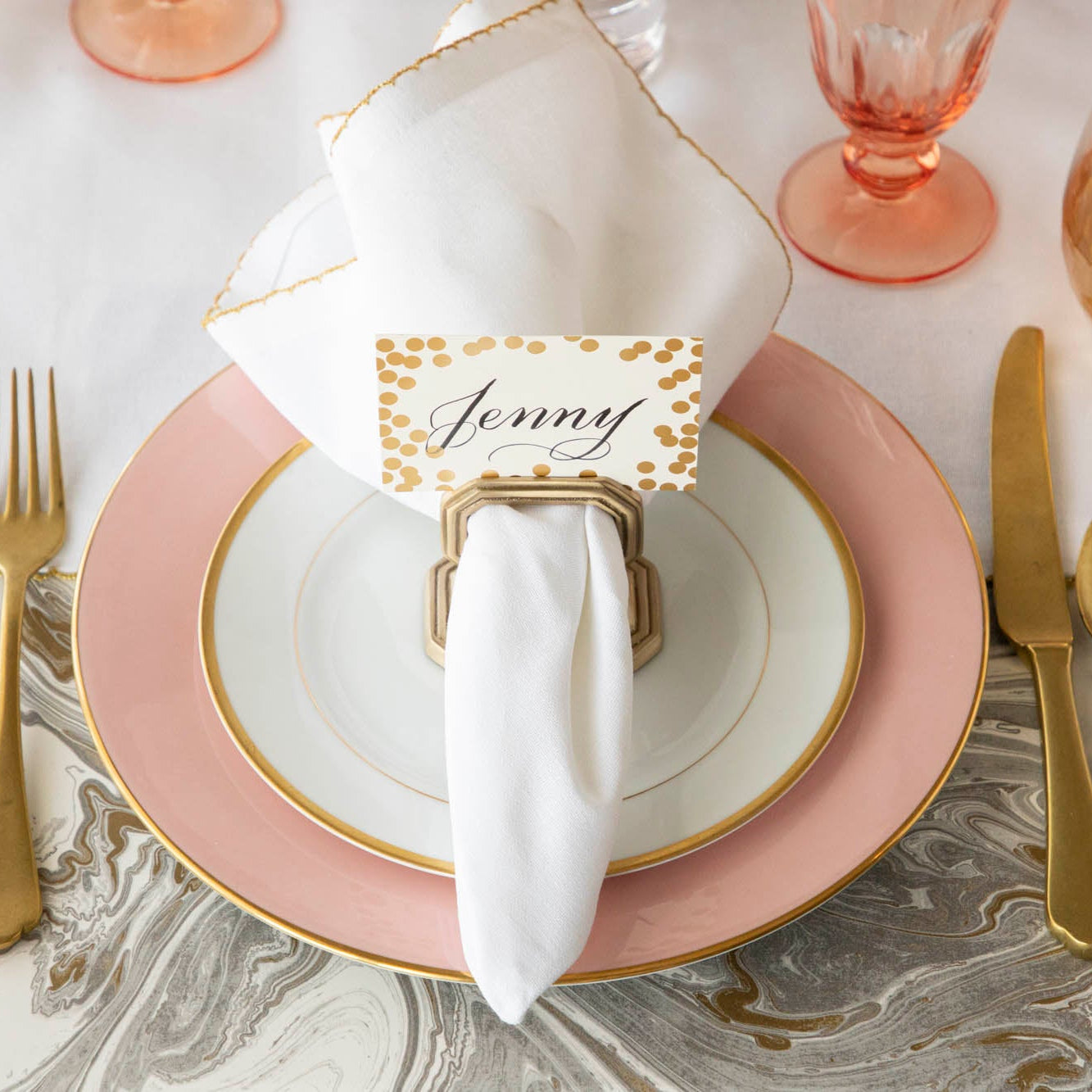 A Brass Napkin Ring with Place Card Holder on the plate of an elegant place setting, from above.