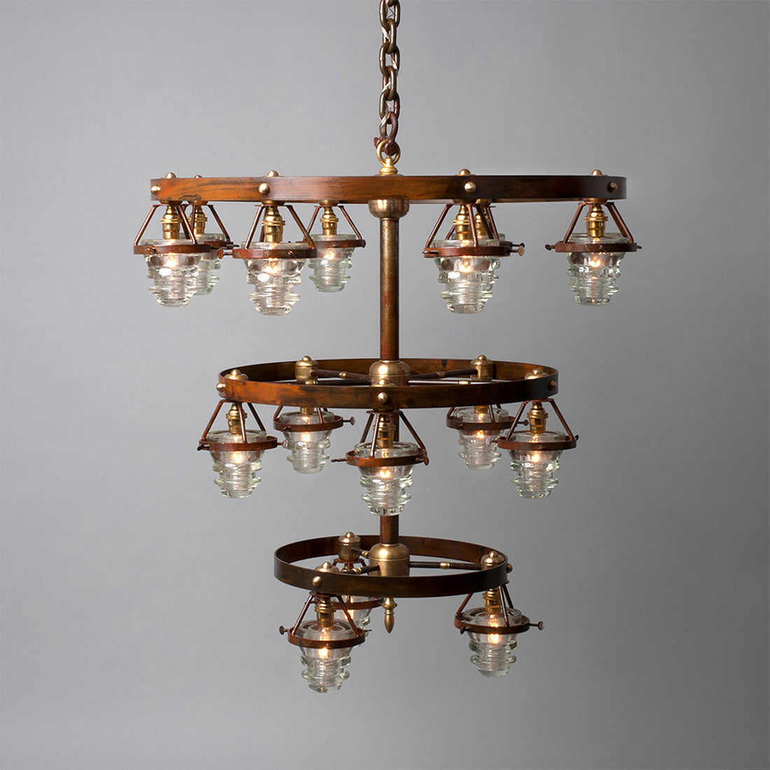 Two-tiered circular Triple Telegraph Chandelier with antique glass insulators, exposed bulbs, and bronze finish by Hester & Cook.