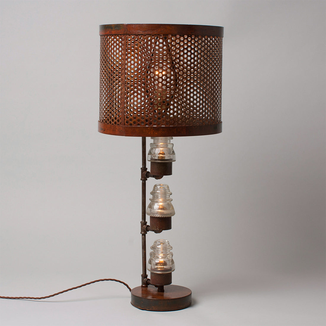 A traditional Hester & Cook Telegraph Table Top Lamp with a metal shade and a basket on top.