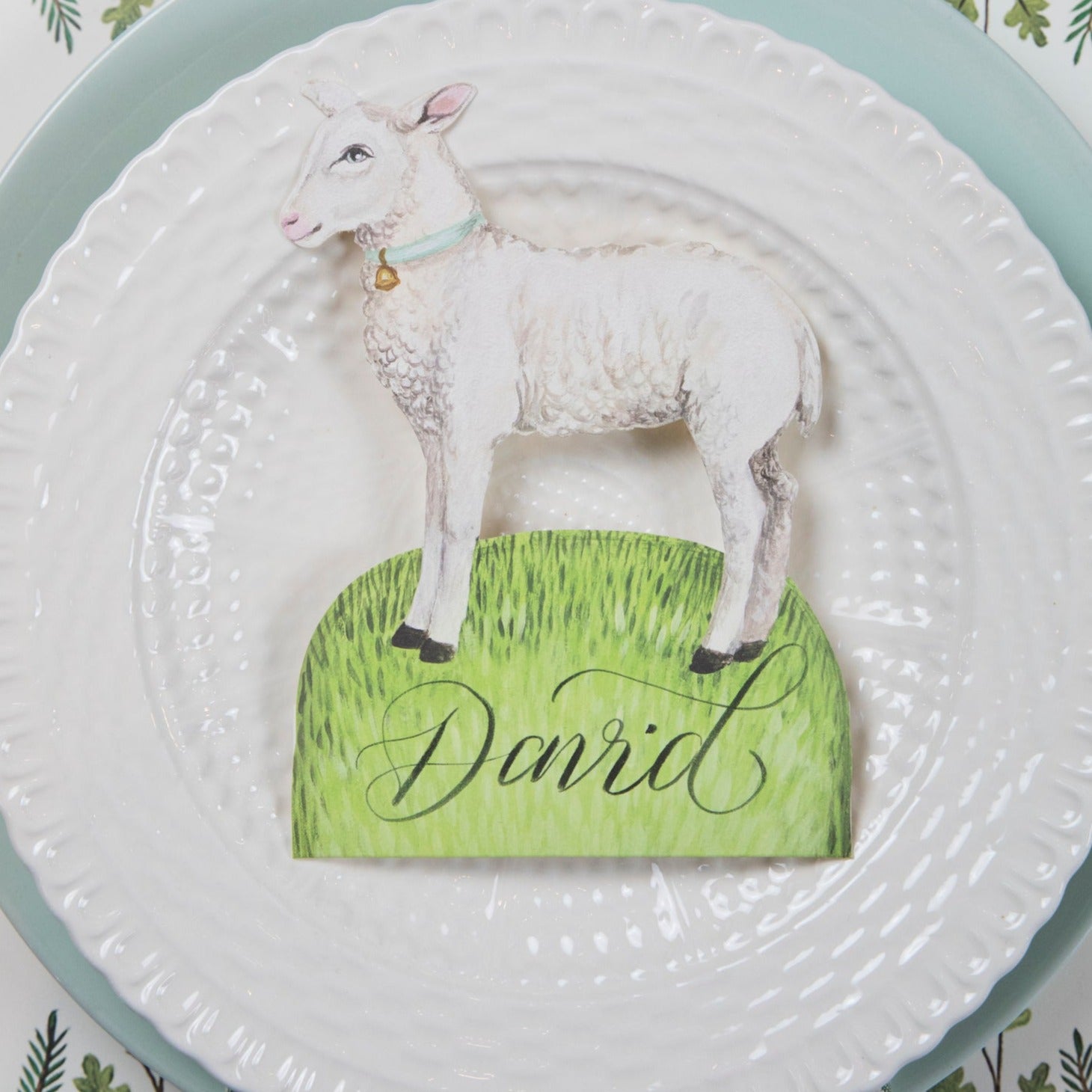 A plate with a Little Lamb place card on it, inspired by the Easter Garden Story, designed by Hester & Cook.