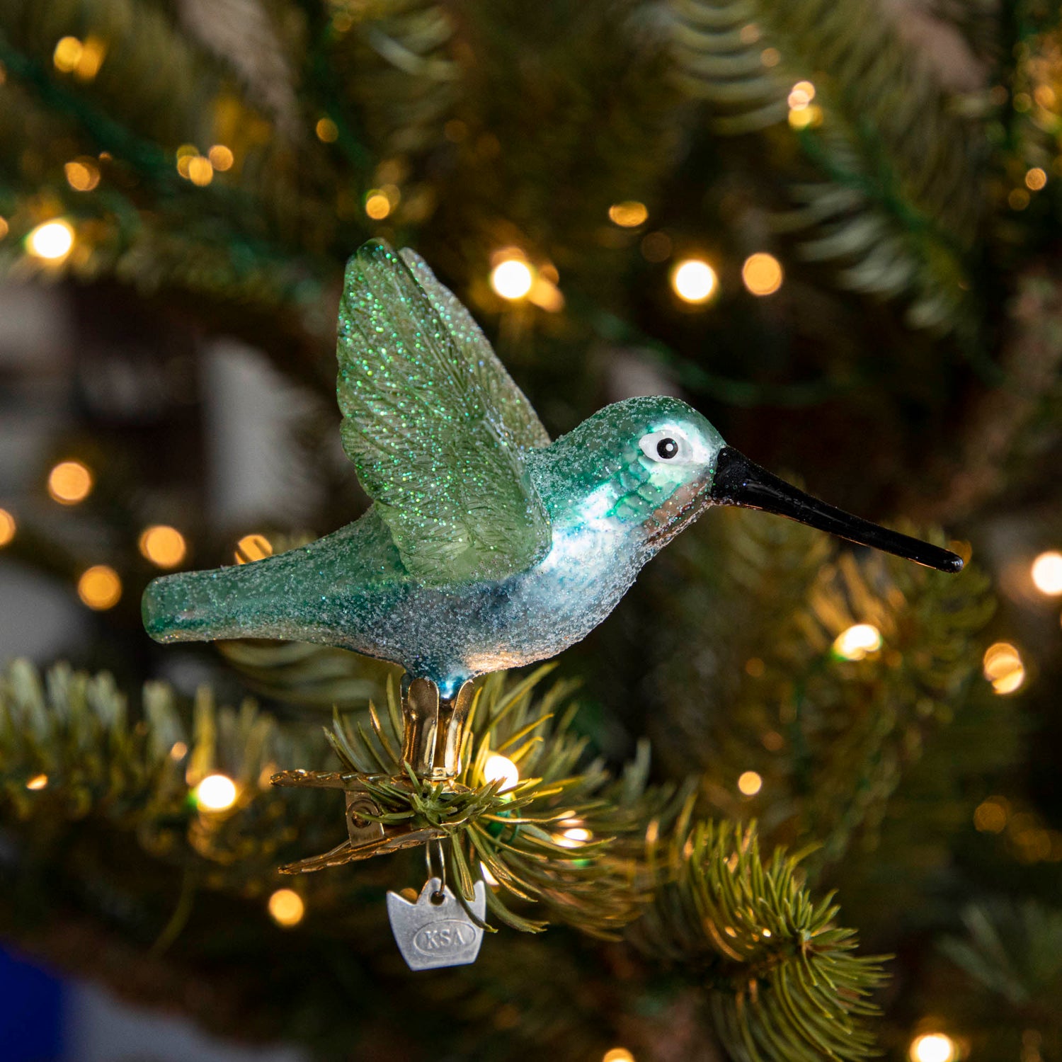 Glass Hummingbird Ornament clipped into a tree.