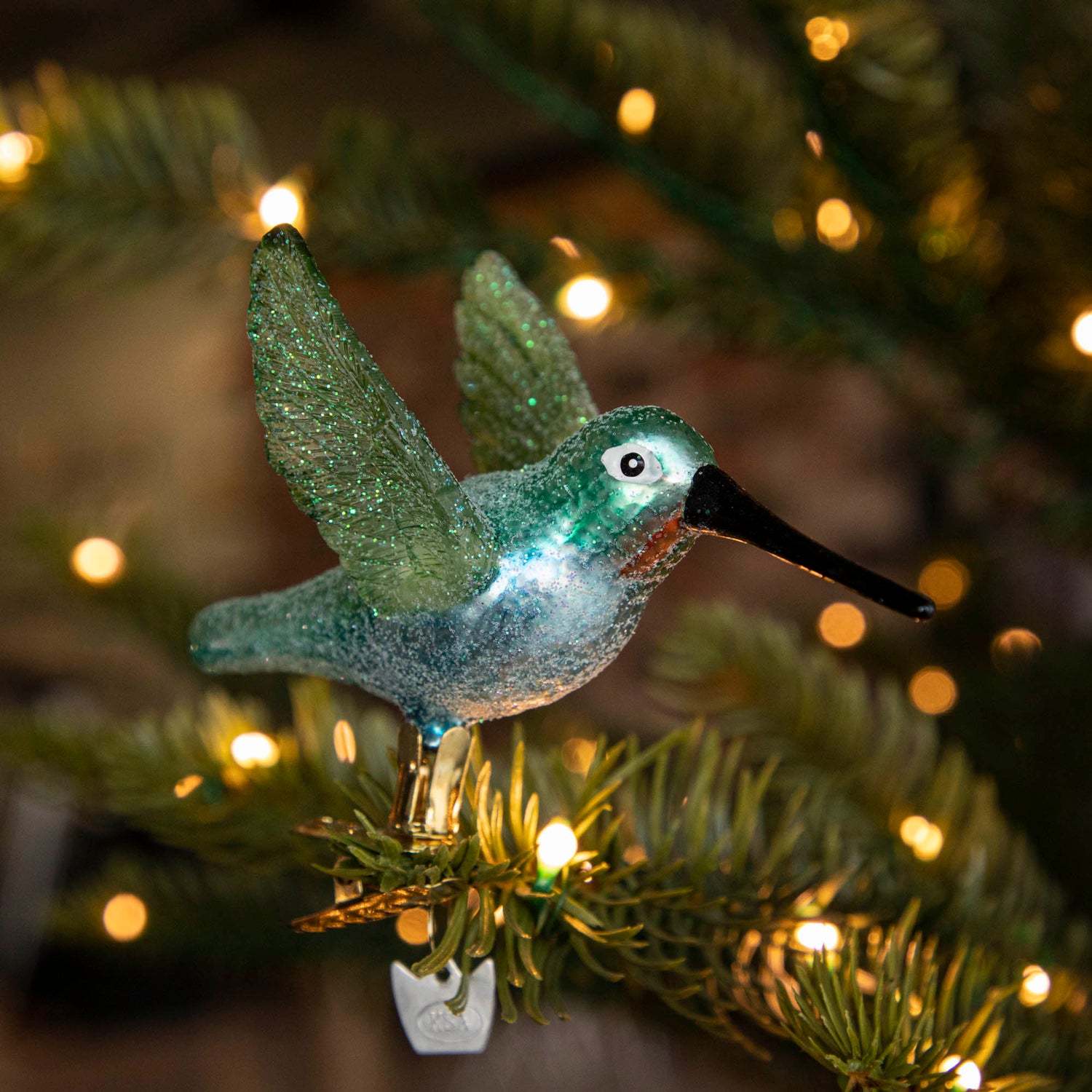 Glass Hummingbird Ornament clipped into a tree.