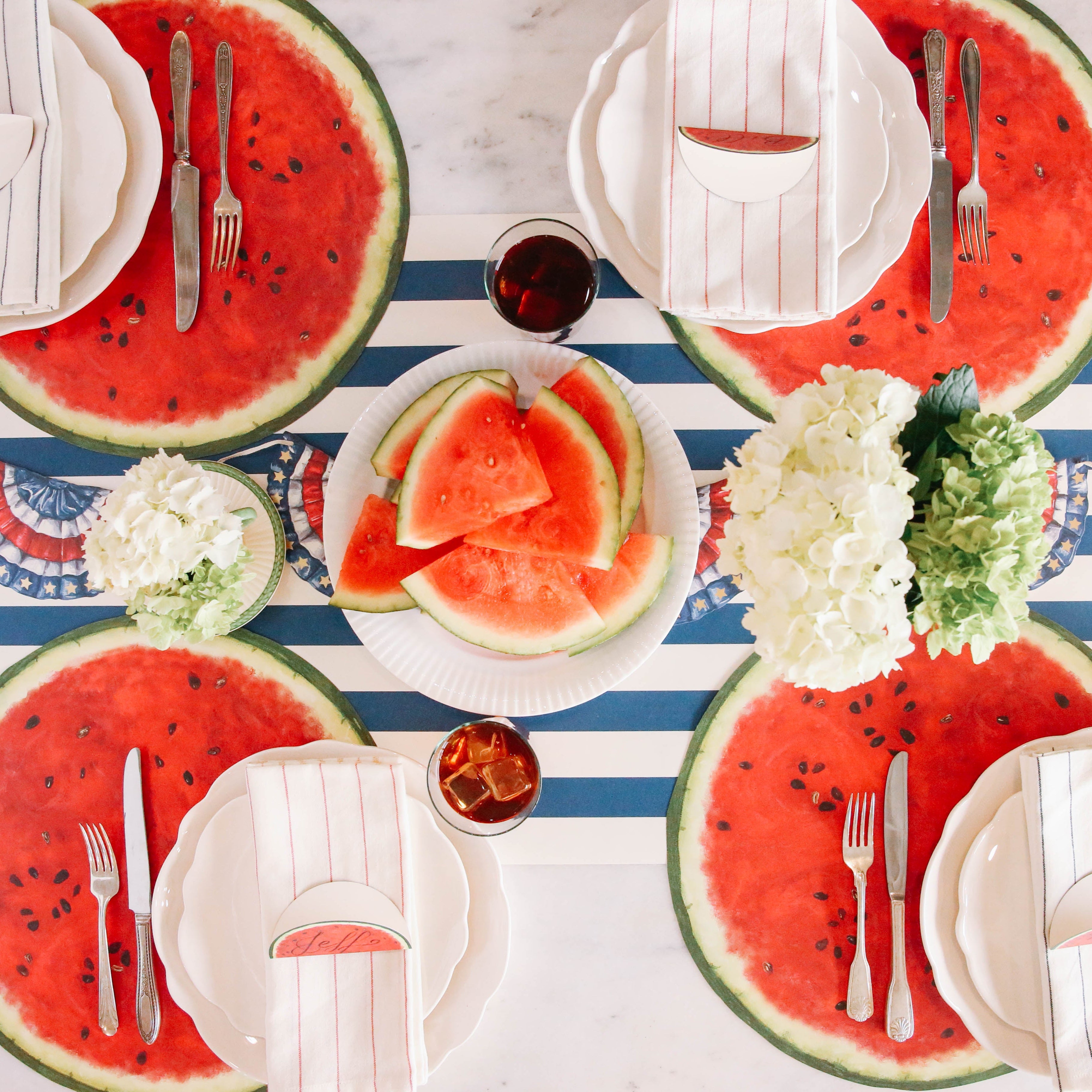 The Die-cut Watermelon Placemat under an elegant summertime table setting for four, from above.